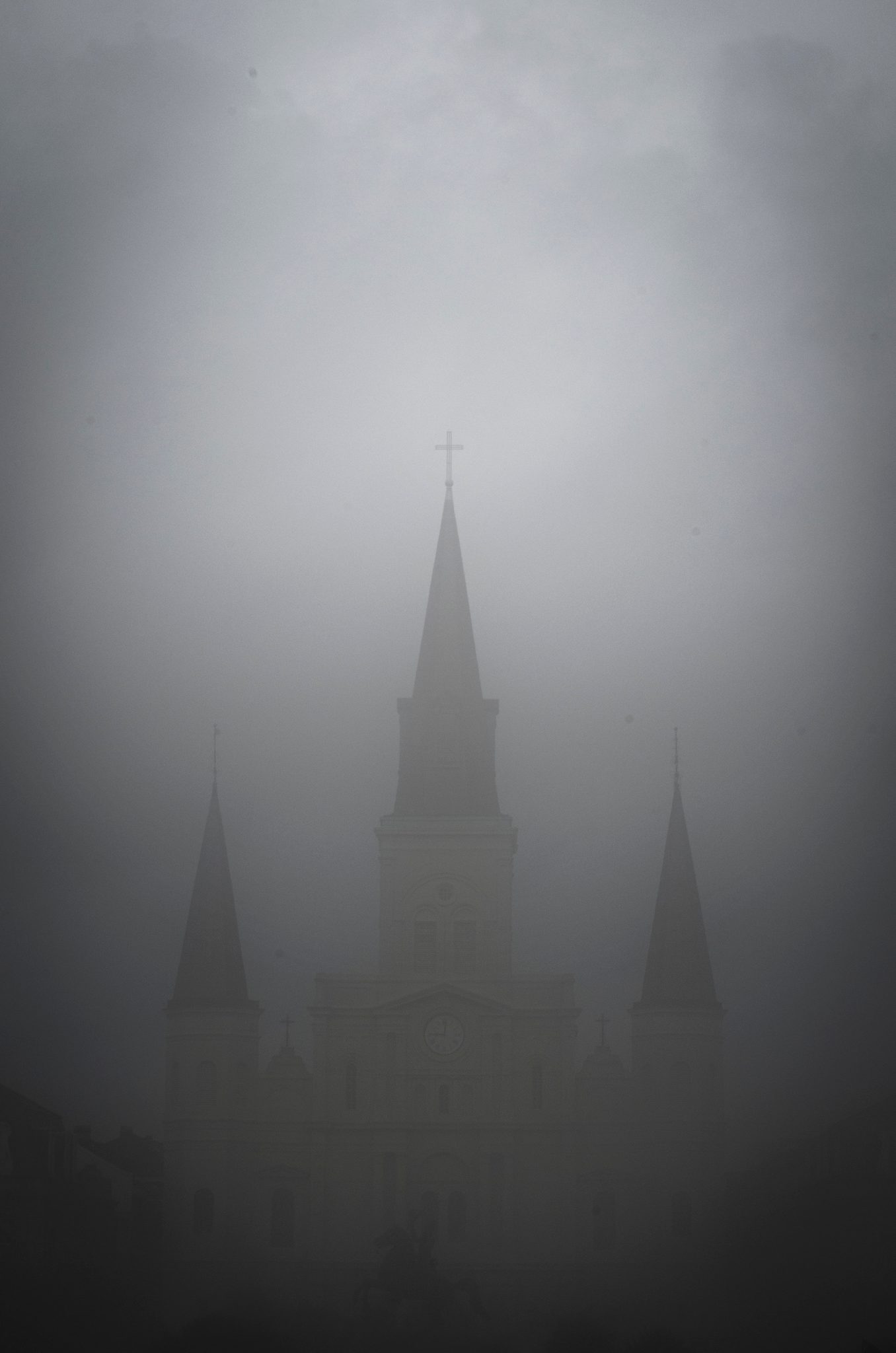 St. Louis Cathedral fades into the fog until only its spires remain.