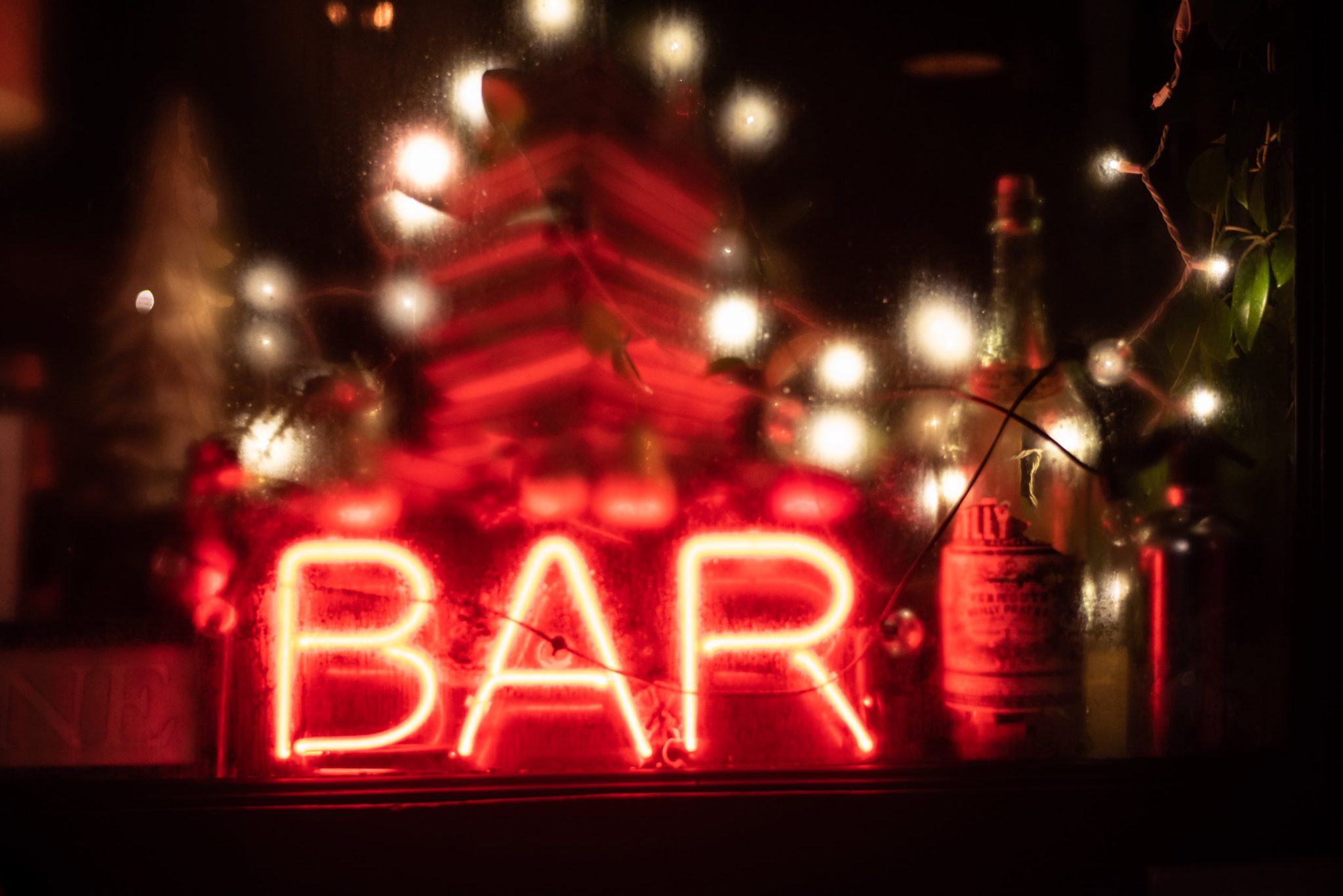 BAR, in red neon, wrapped in holiday lights.