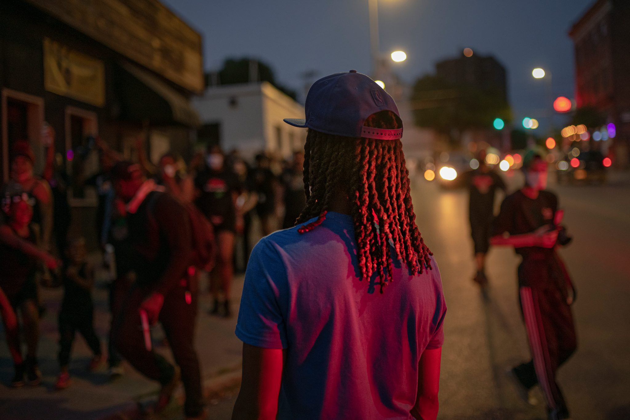 The march glows red under the streetlights at dusk.