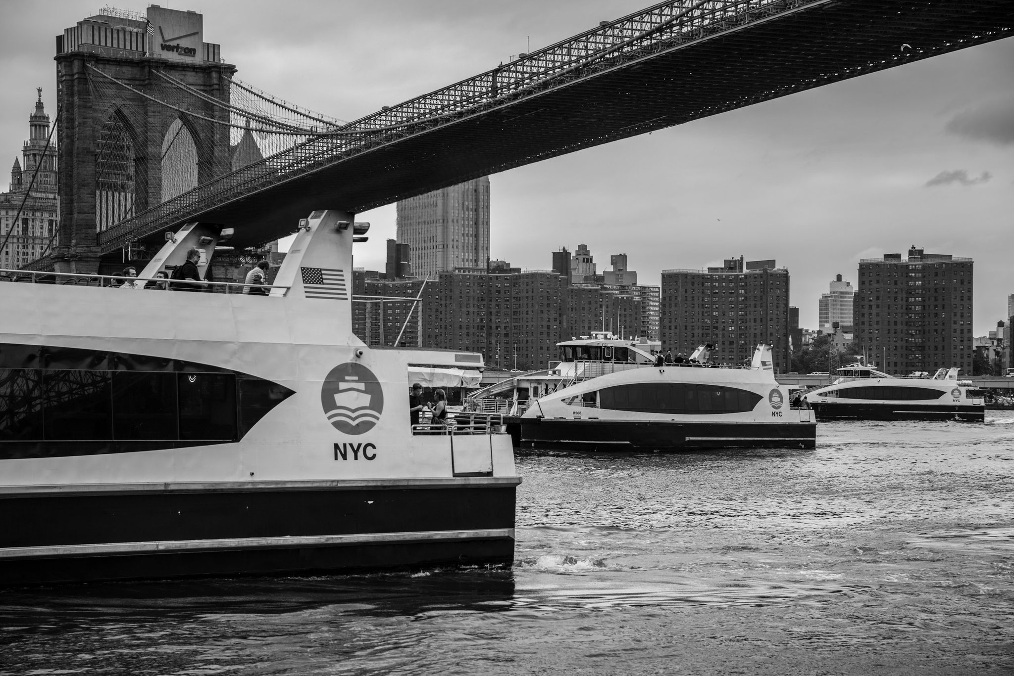 Ferries churn the East River beneath the Brooklyn Bridge.