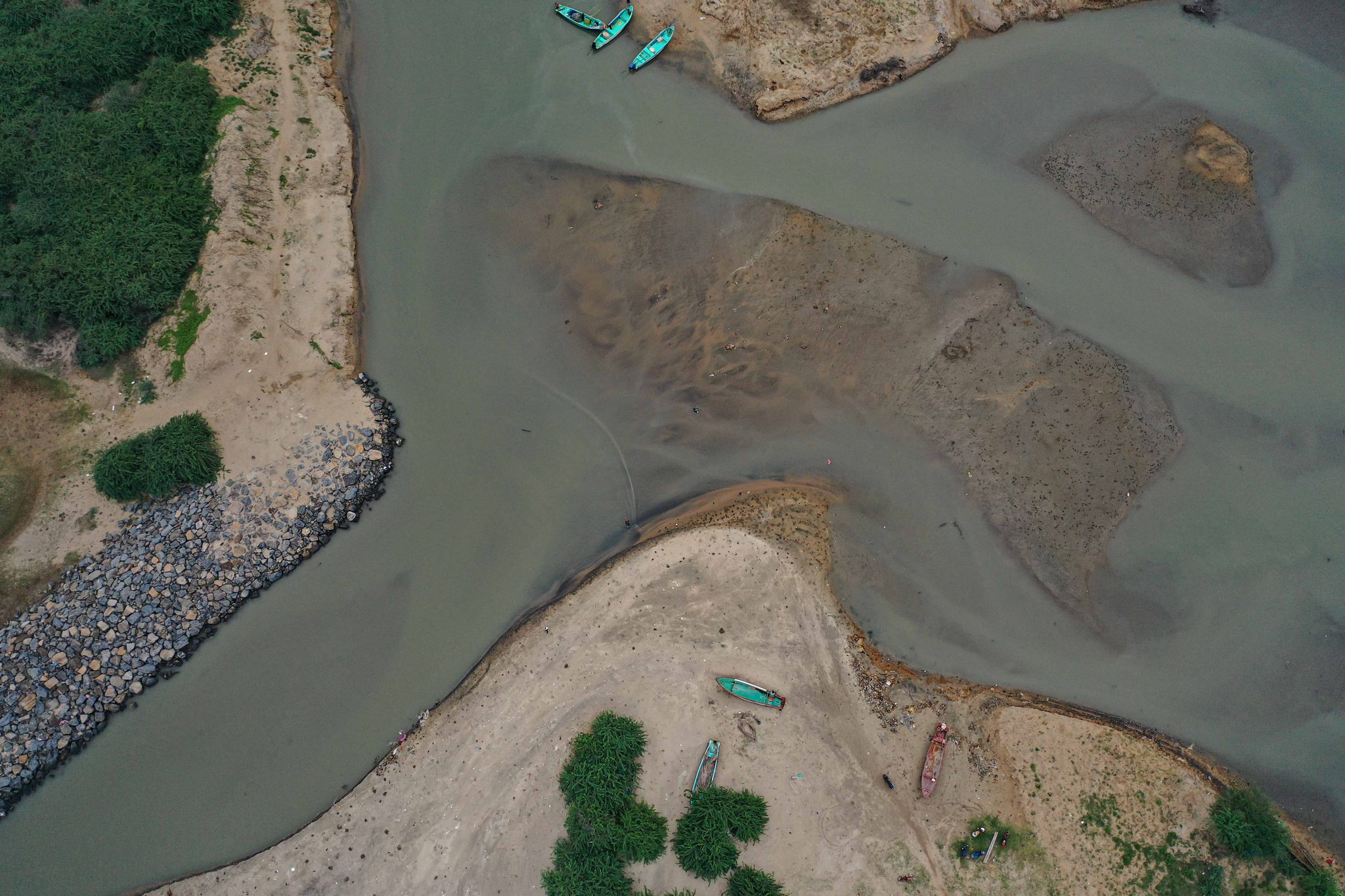 The channel curls past a stone embankment, seen from above.