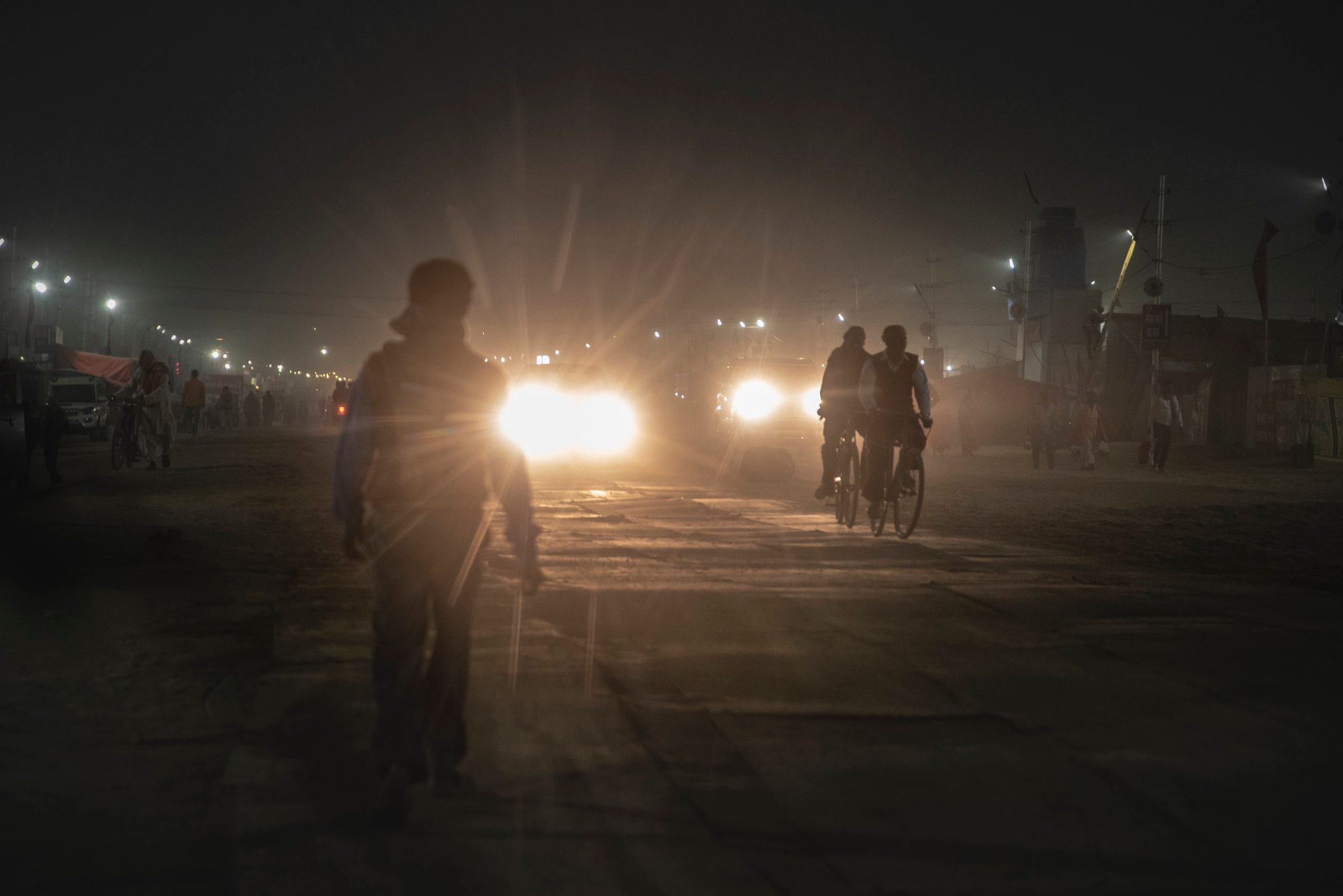 People travel along the dirt roads lined with steel plates