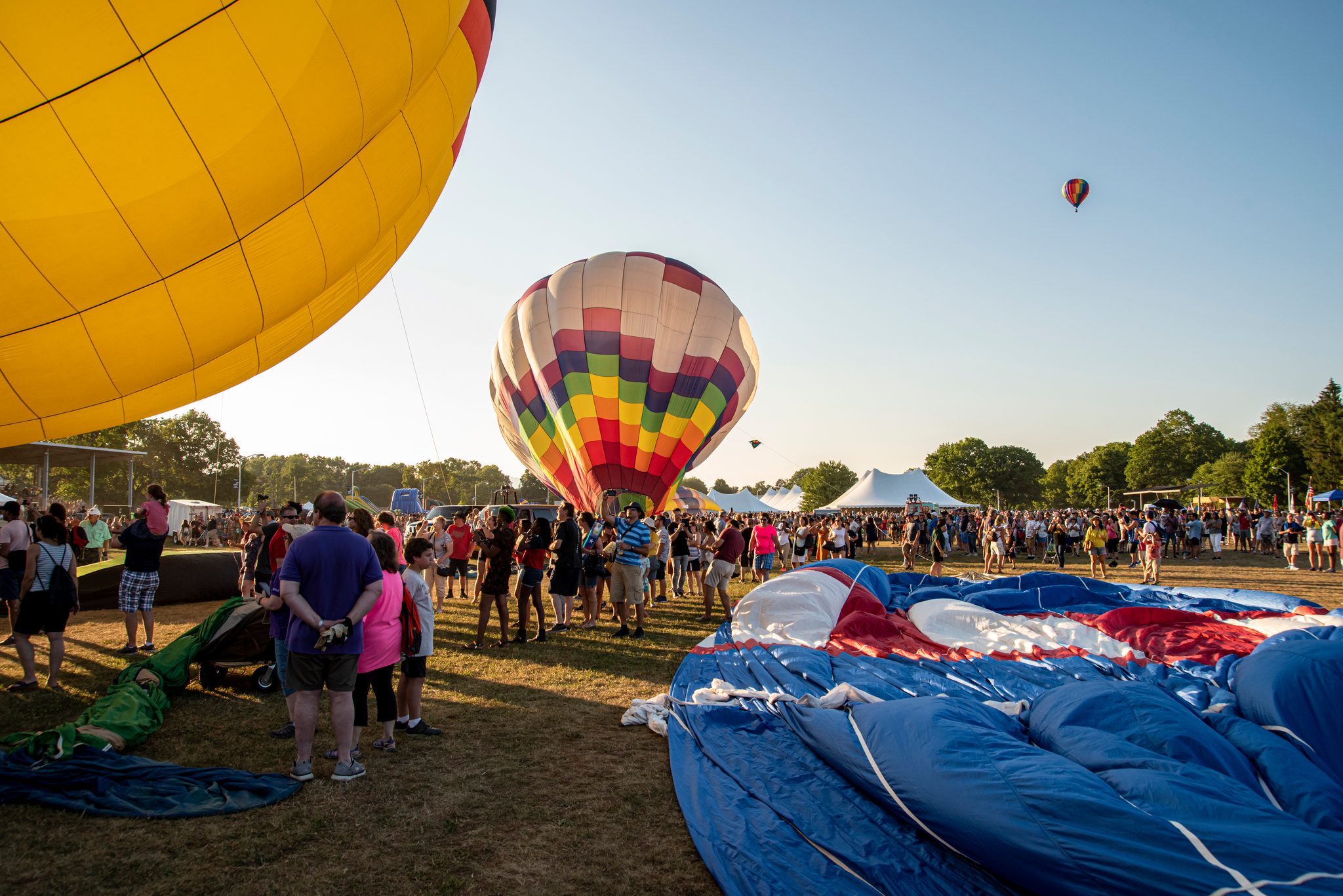 Envelopes swell across the field as the crowd wanders between them.