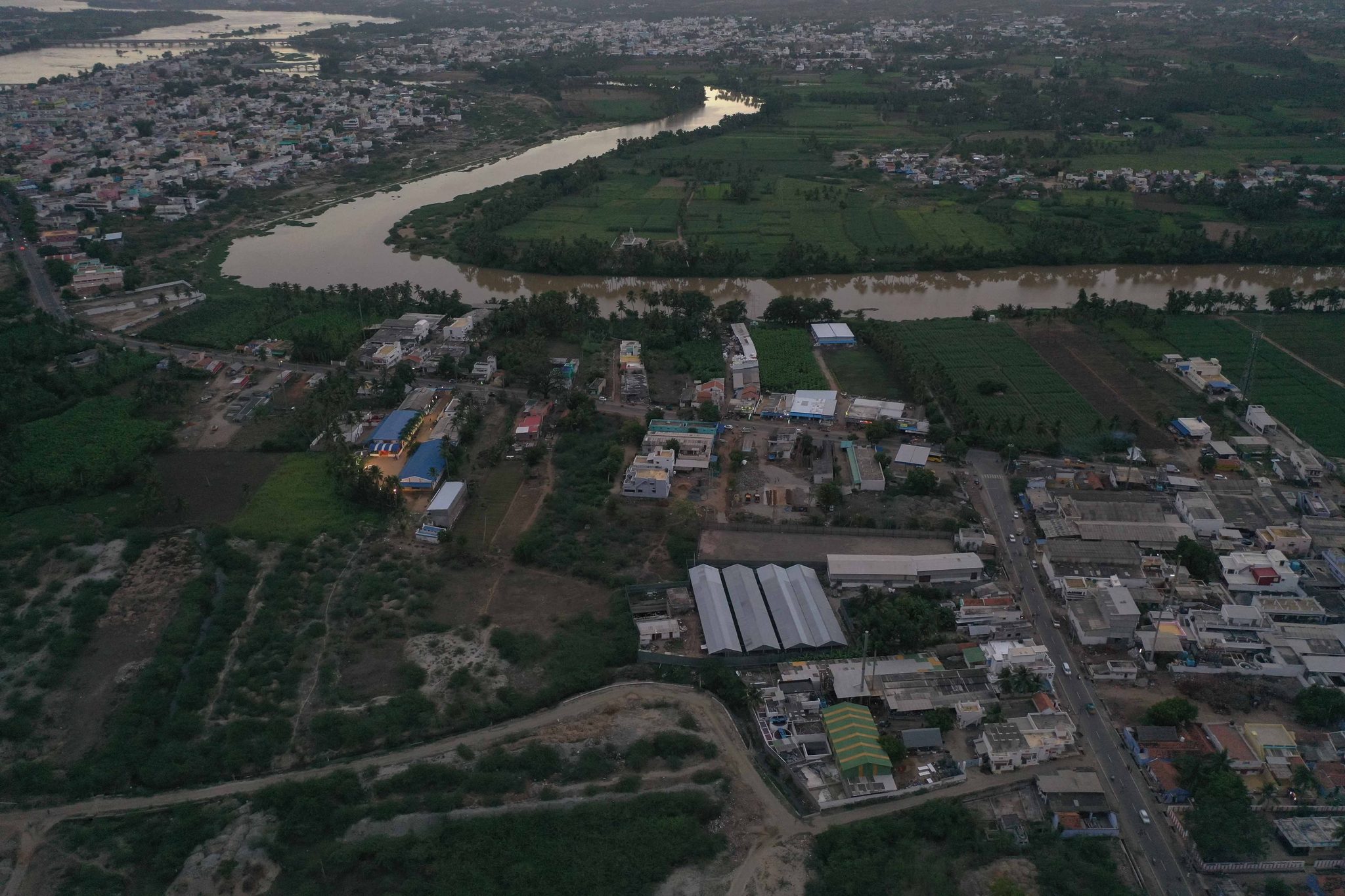 The town crowds the riverbank, the water curving away into the haze.