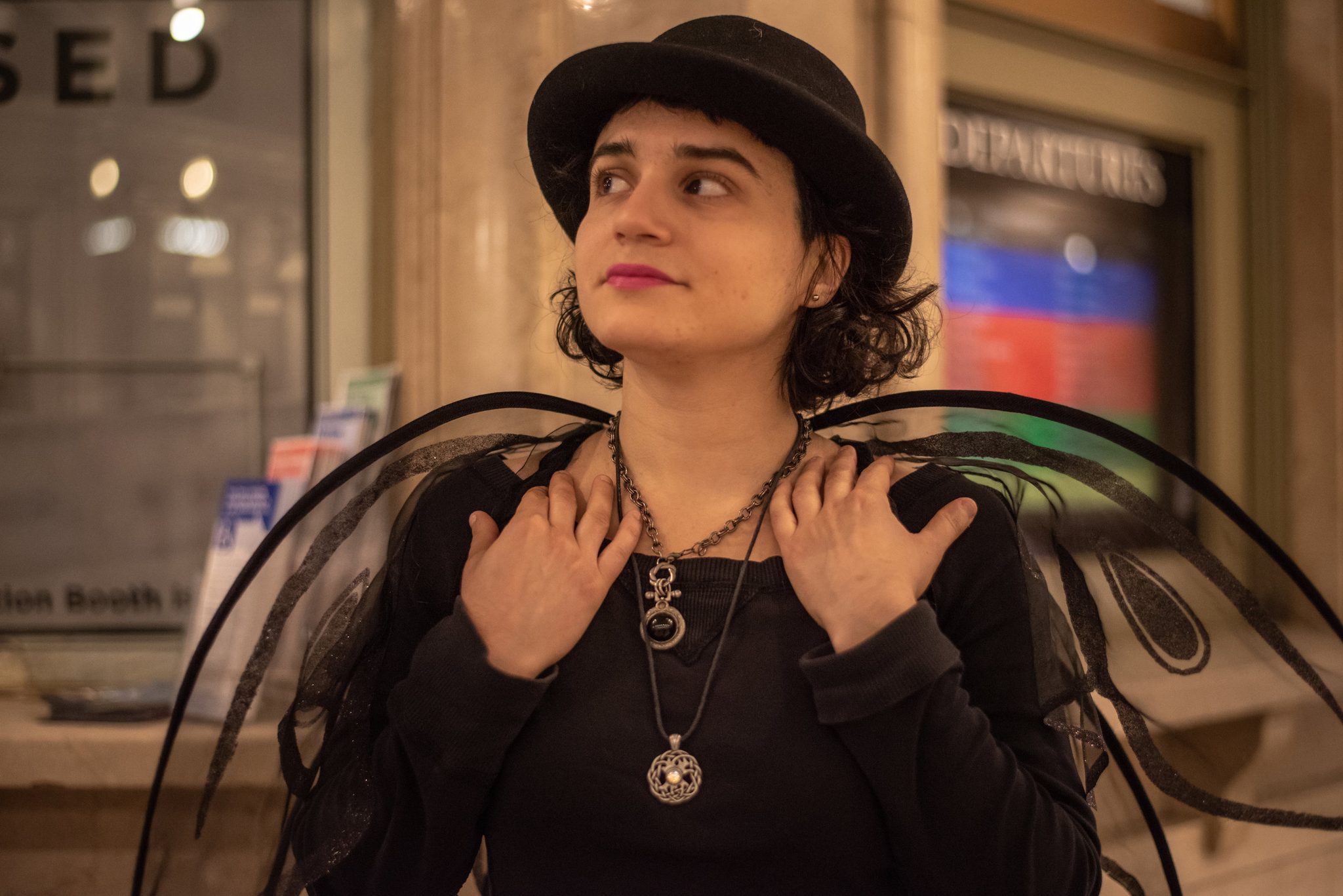 Samantha Echo, wings on her shoulders, looks up into the great hall.