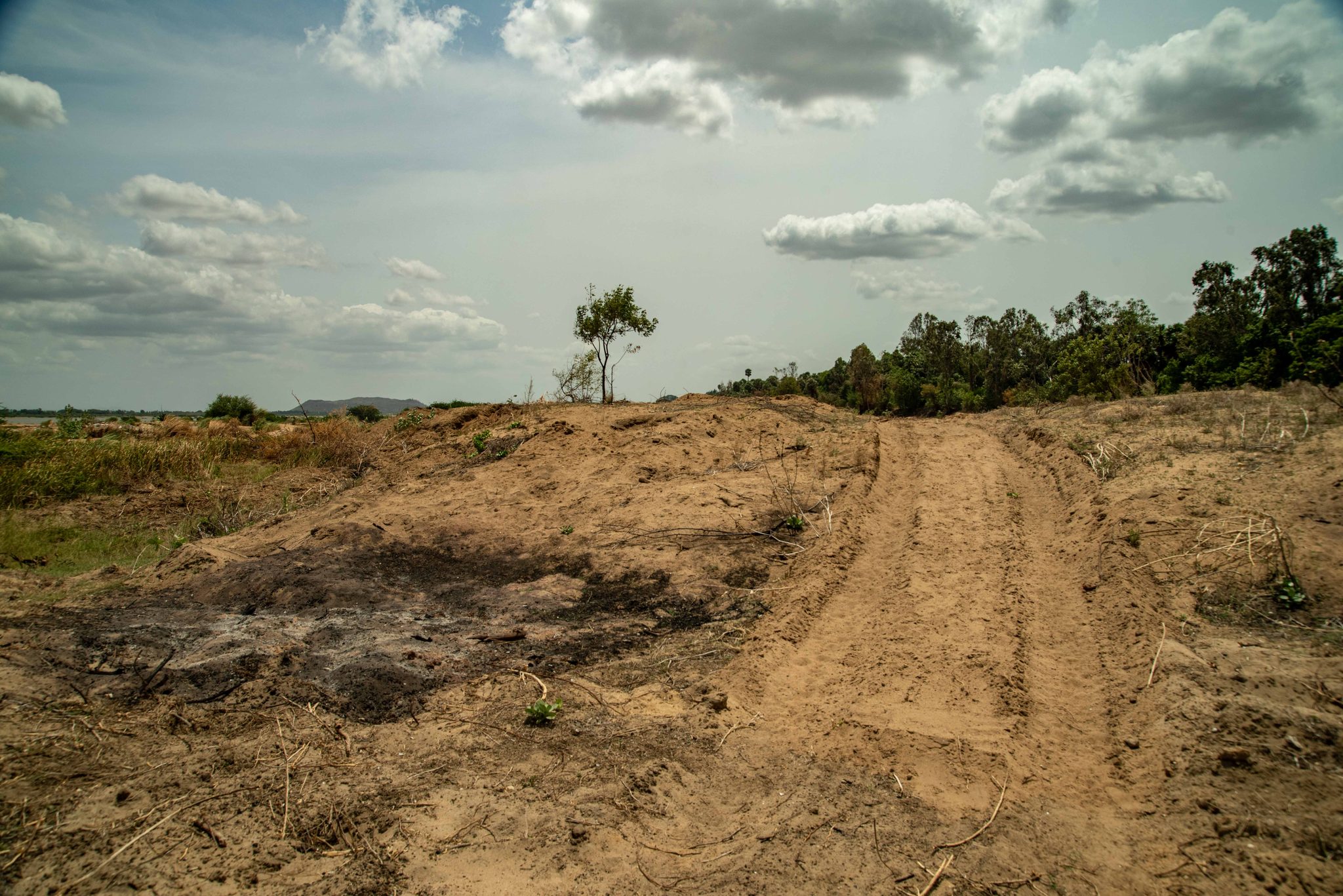 A dirt track climbs over the dry, burned ground.