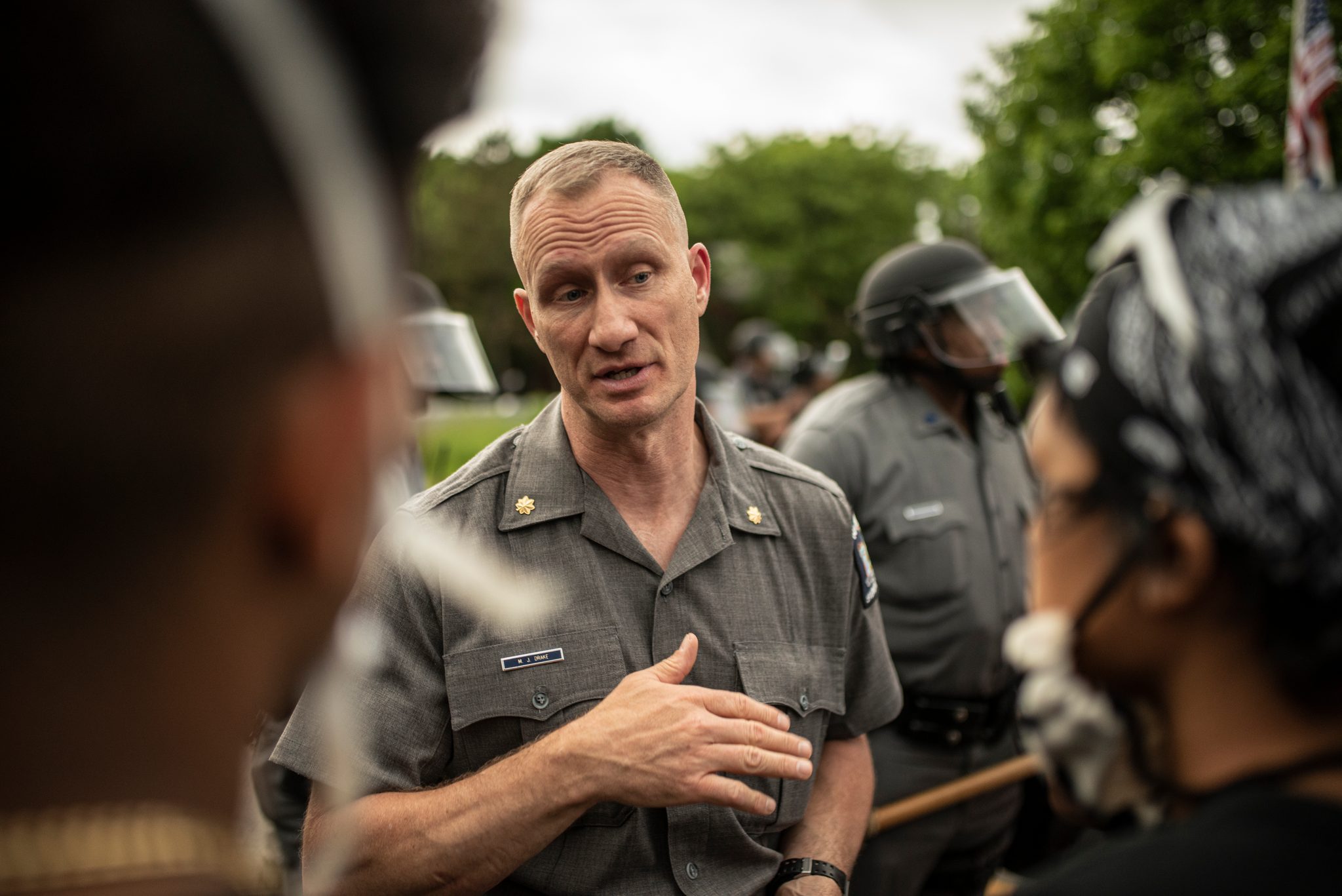 A state police officer puts a hand to his chest as he talks with the marchers.