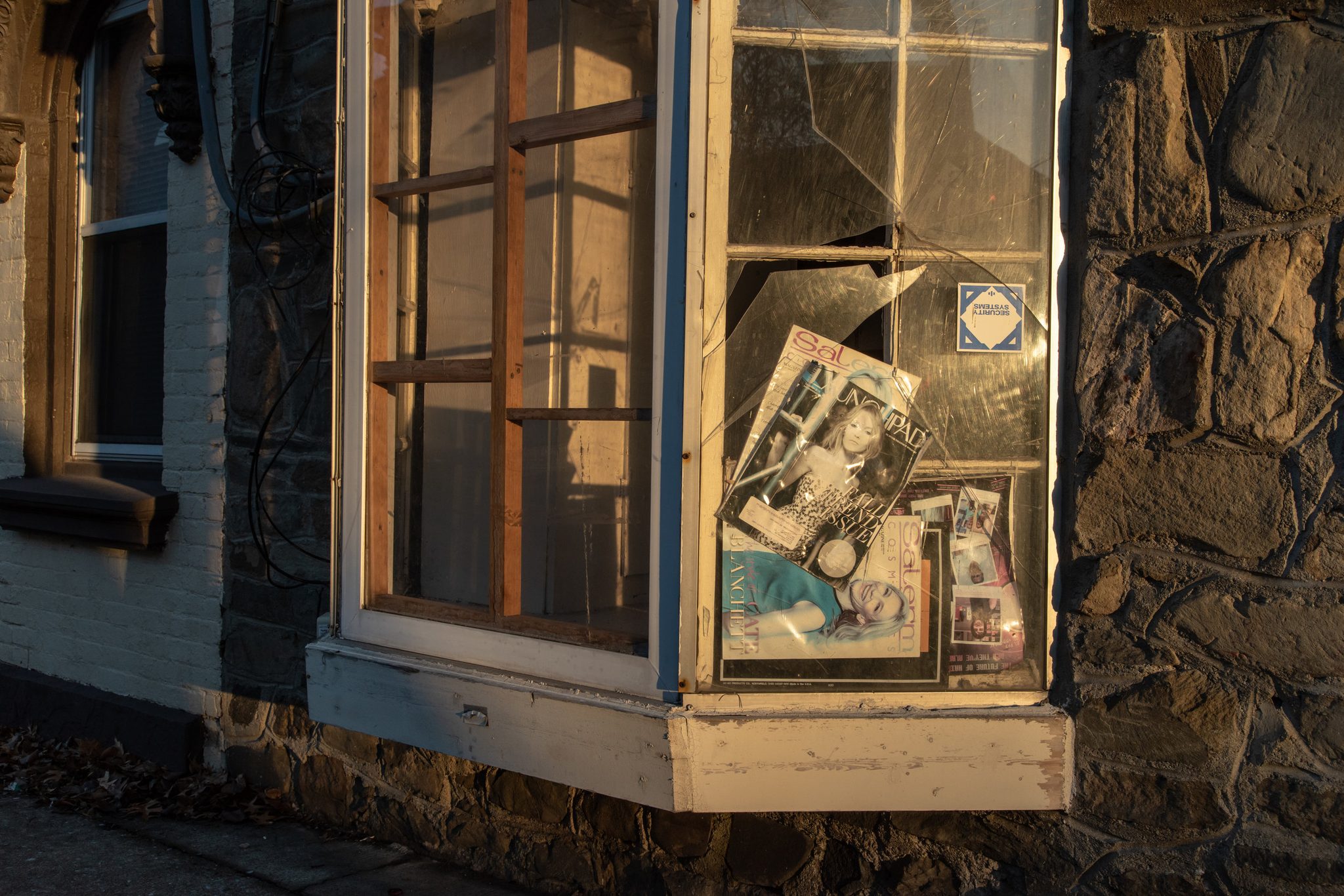 A broken window, old magazines still leaning in the glass.