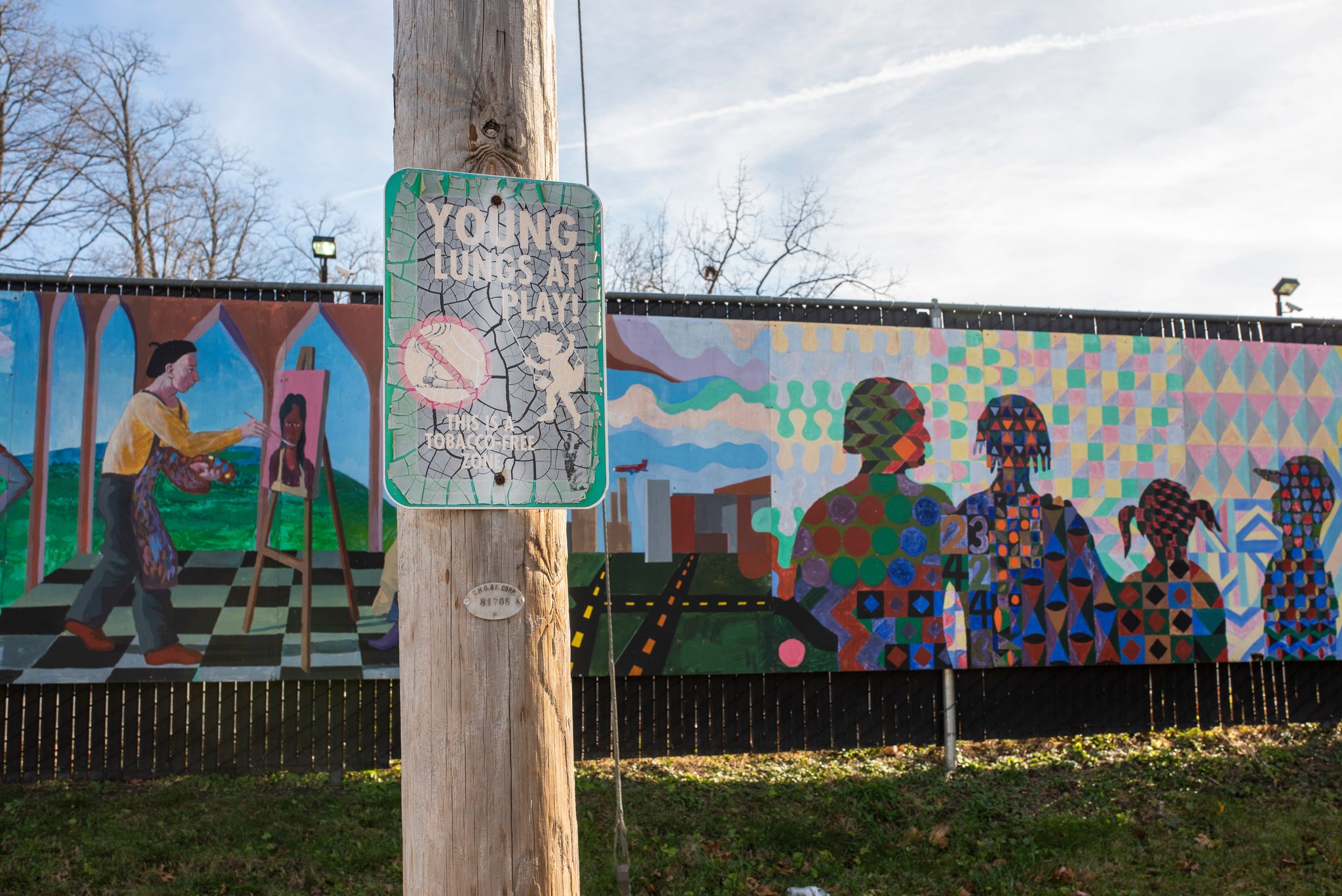 A long mural of neighbors lines the basketball court where the youth cleanup begins.