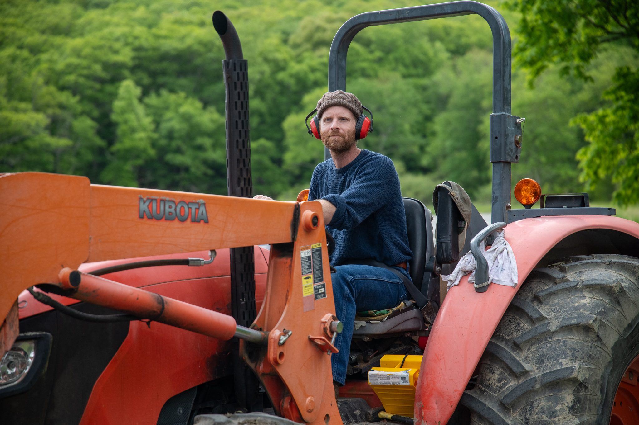 The tractor driver waits at the wheel, ear protection on, for the next load of riders.