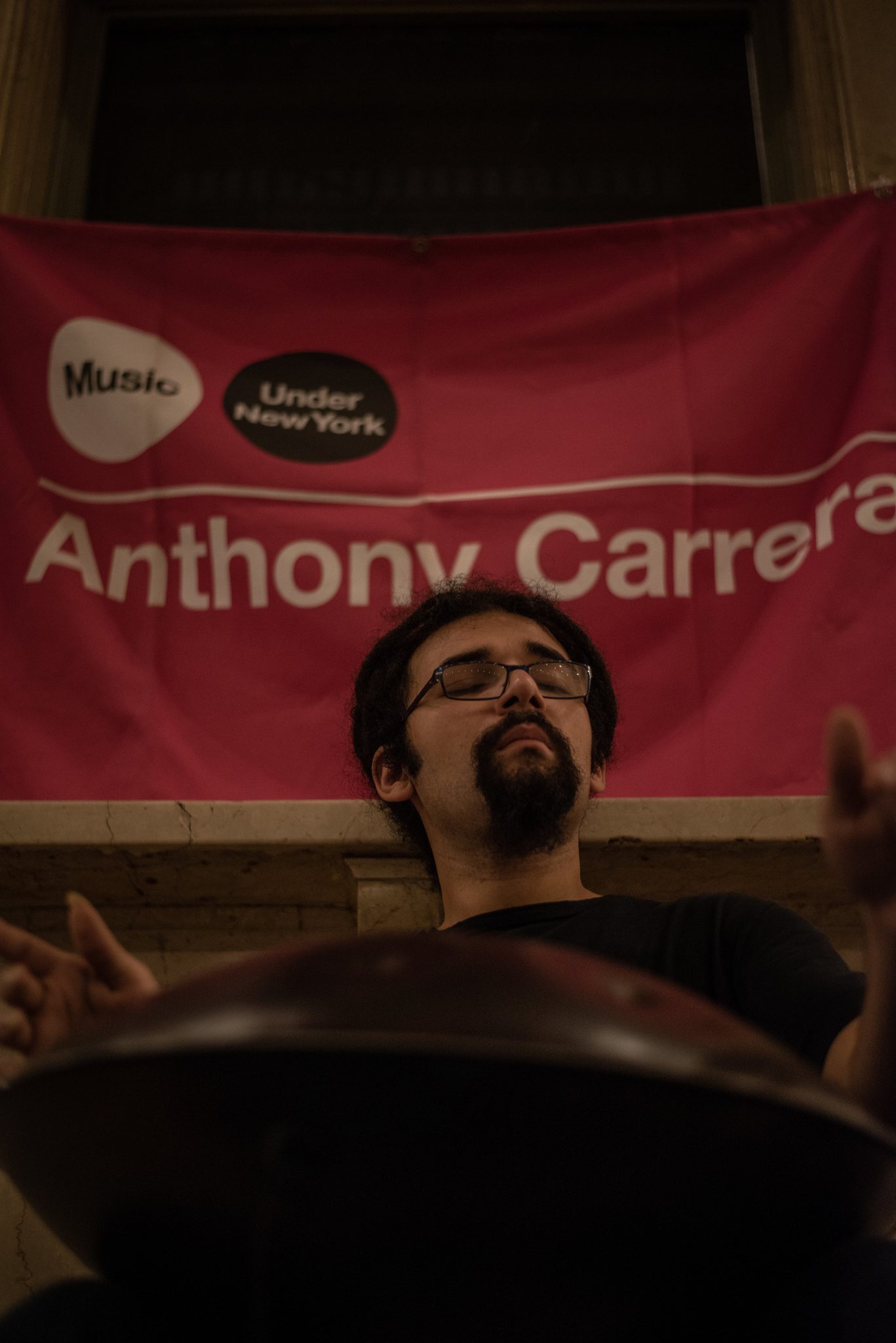 Head tipped back, eyes closed, Anthony plays beneath his Music Under New York banner.