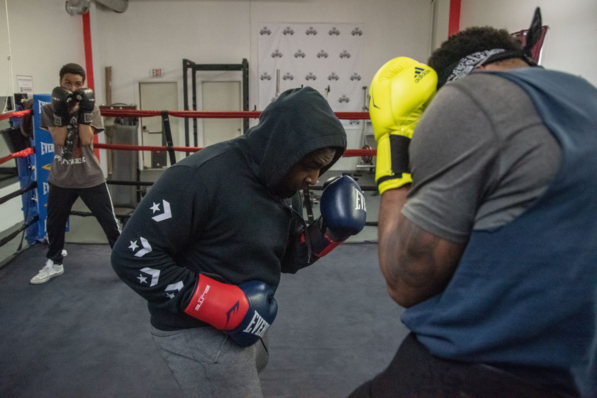 Sparring in the ring while a camera rolls in the corner.