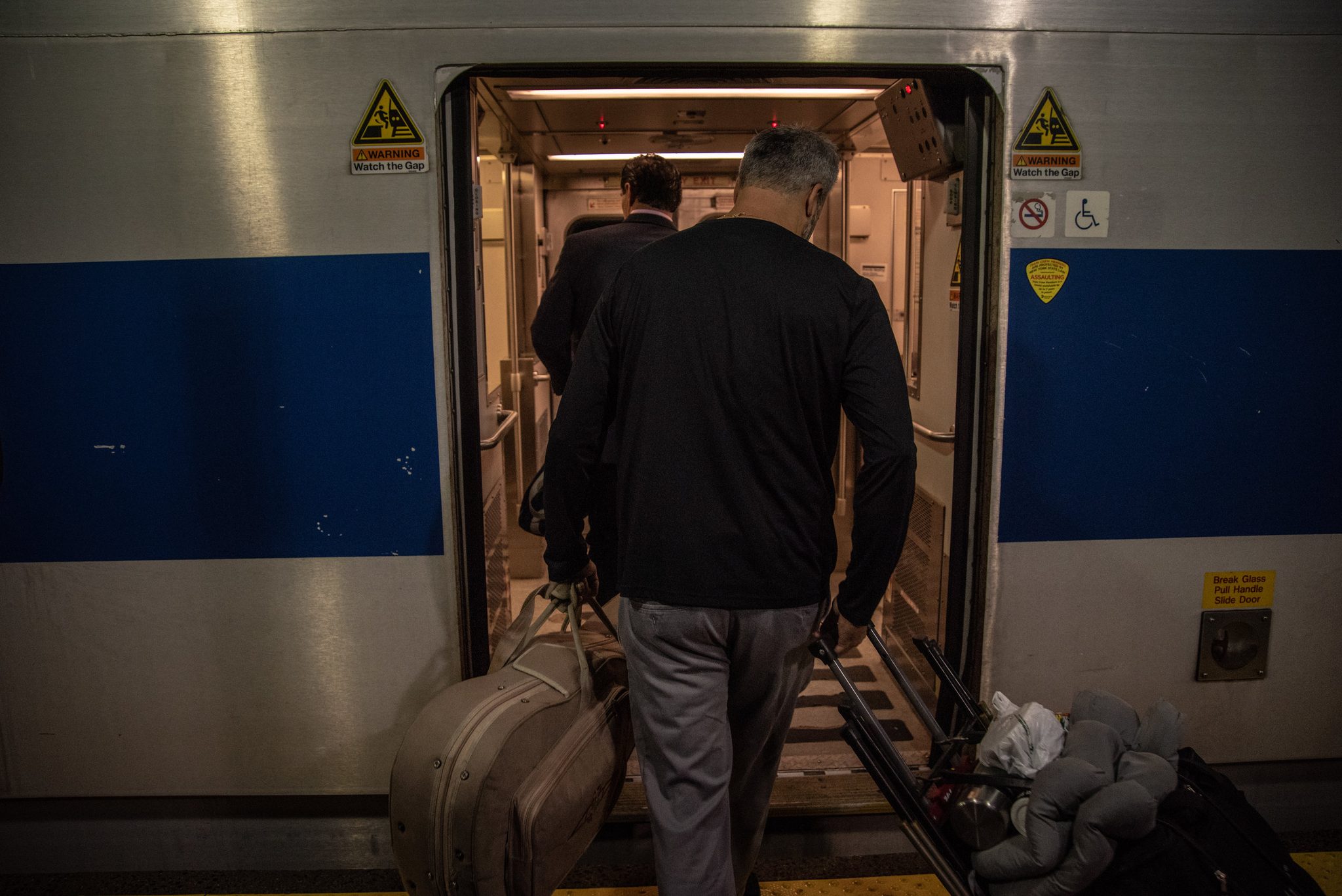 Guitar case in hand, Glenn steps onto the train.