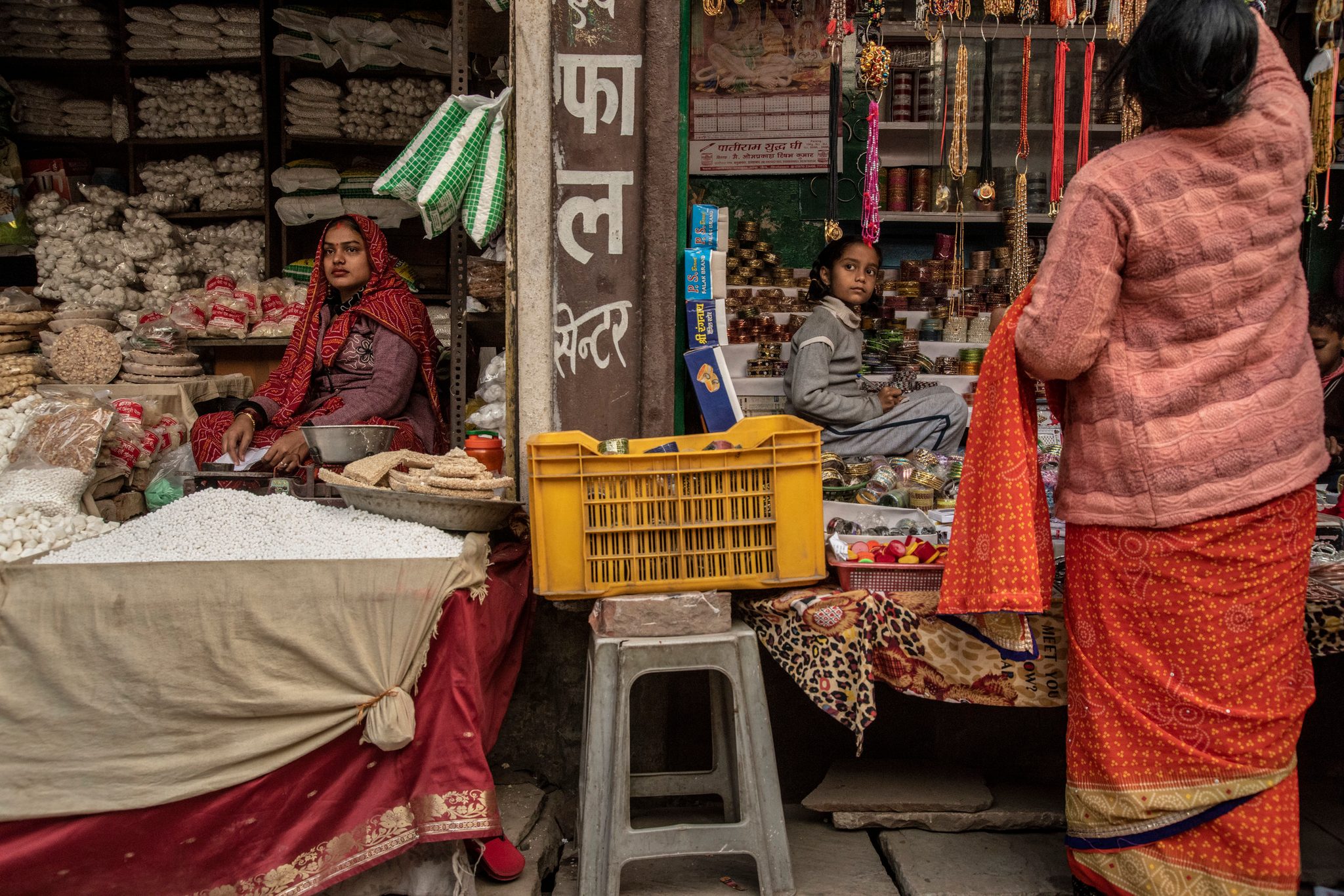 A woman and a young girl in a market in Allahabad, though divided, share the same