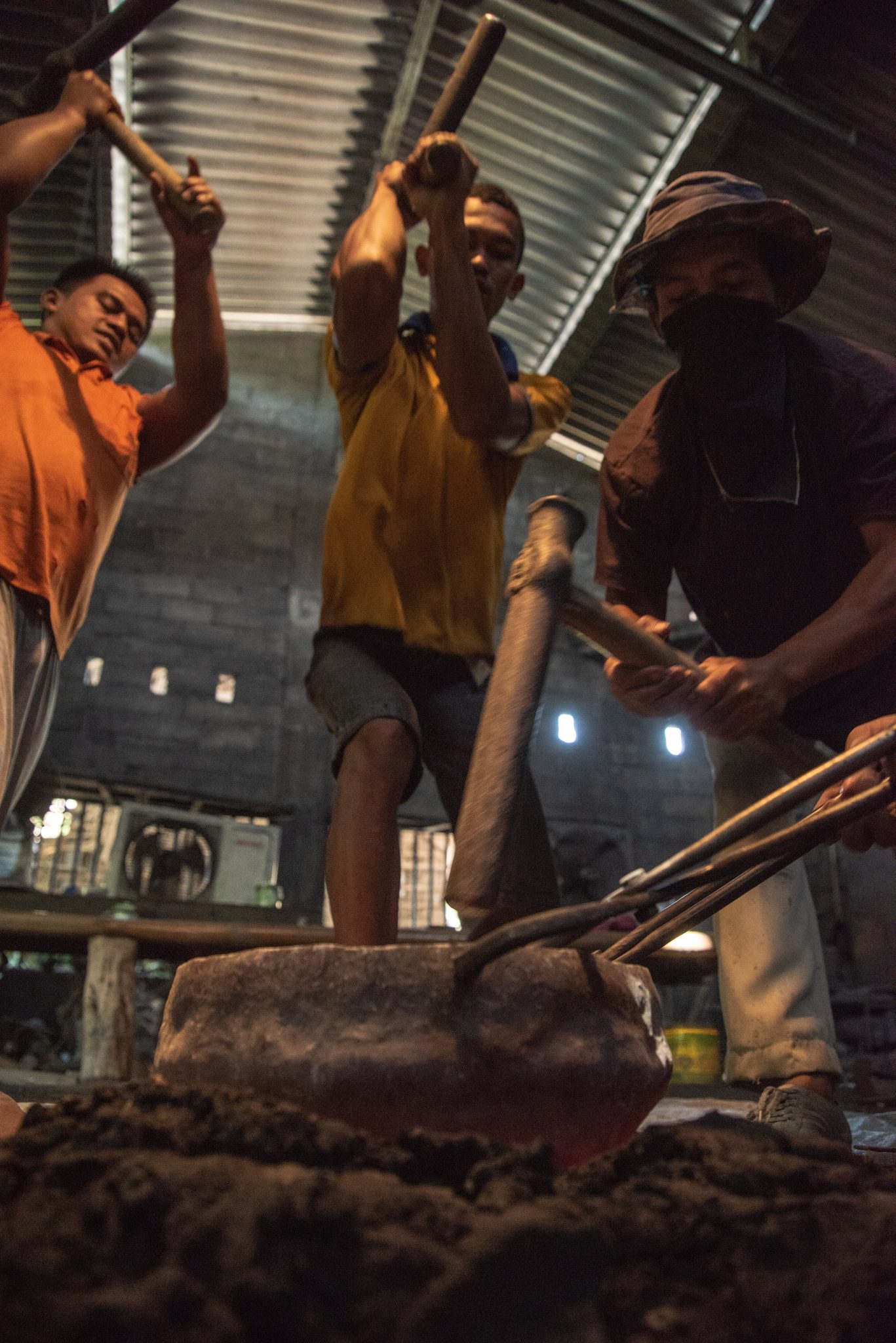 Gong is hammered by a team of blacksmiths