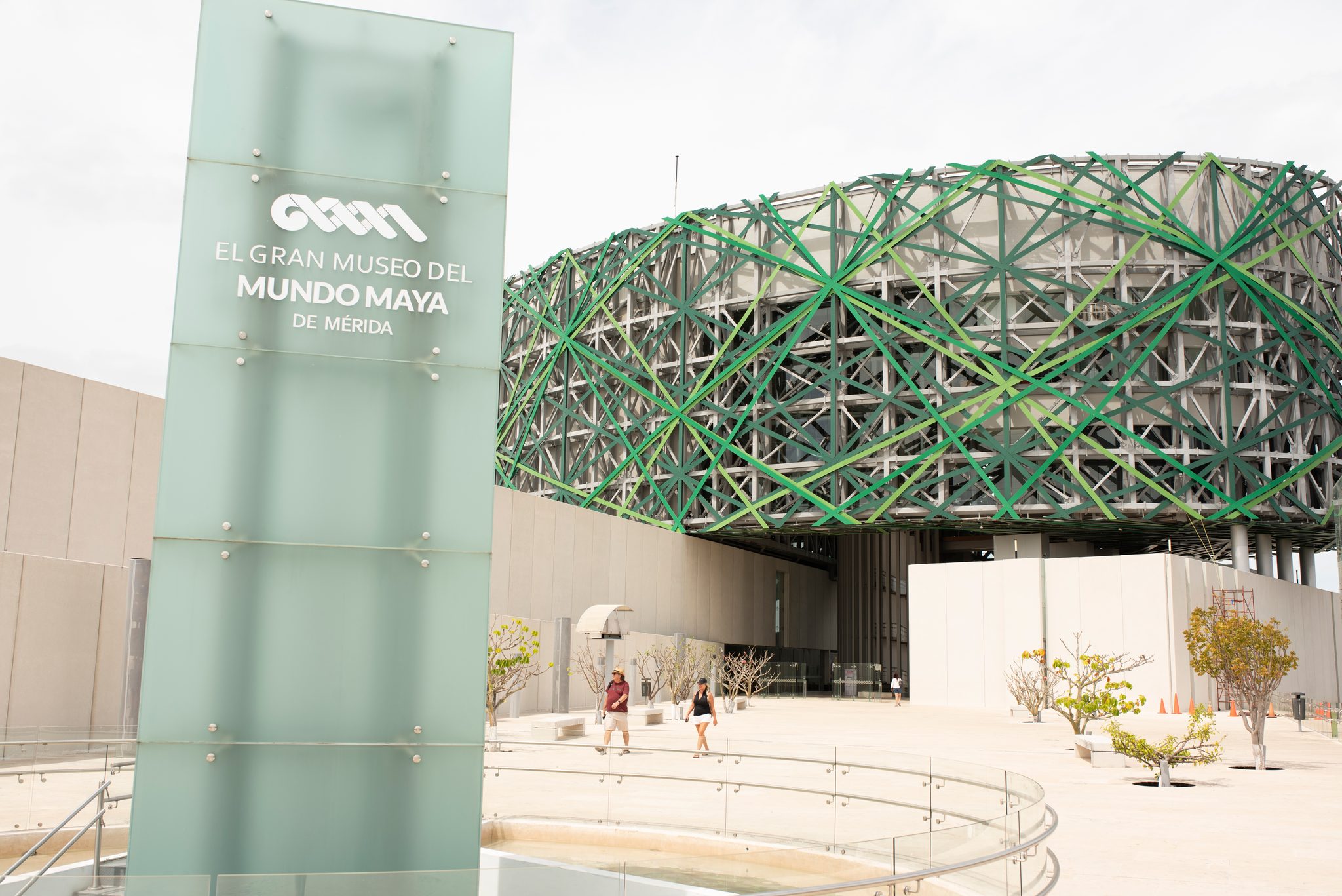 The museum's sign stands in the sun beneath its woven green canopy.