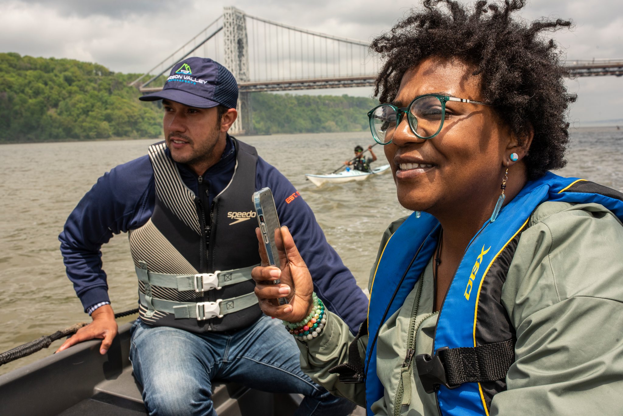 On the support boat, a phone comes out and a wide smile, the George Washington Bridge still in view behind.