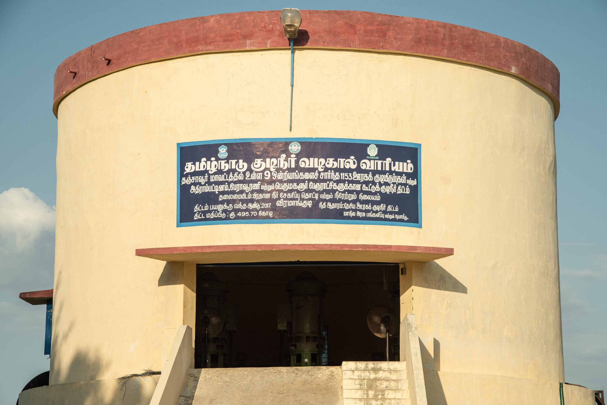 The round pumping station stands under a clear blue sky.