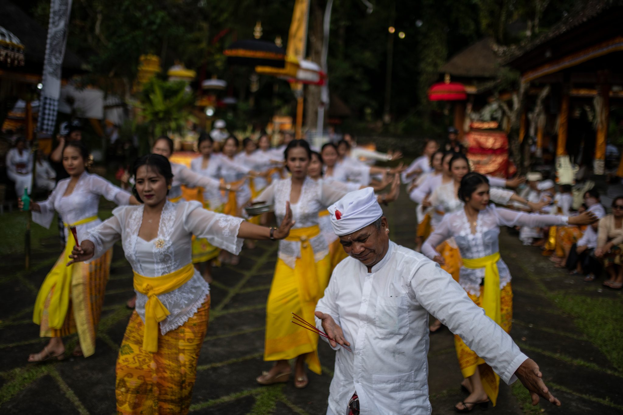 The dance moves as one body, hands turning in the evening light.