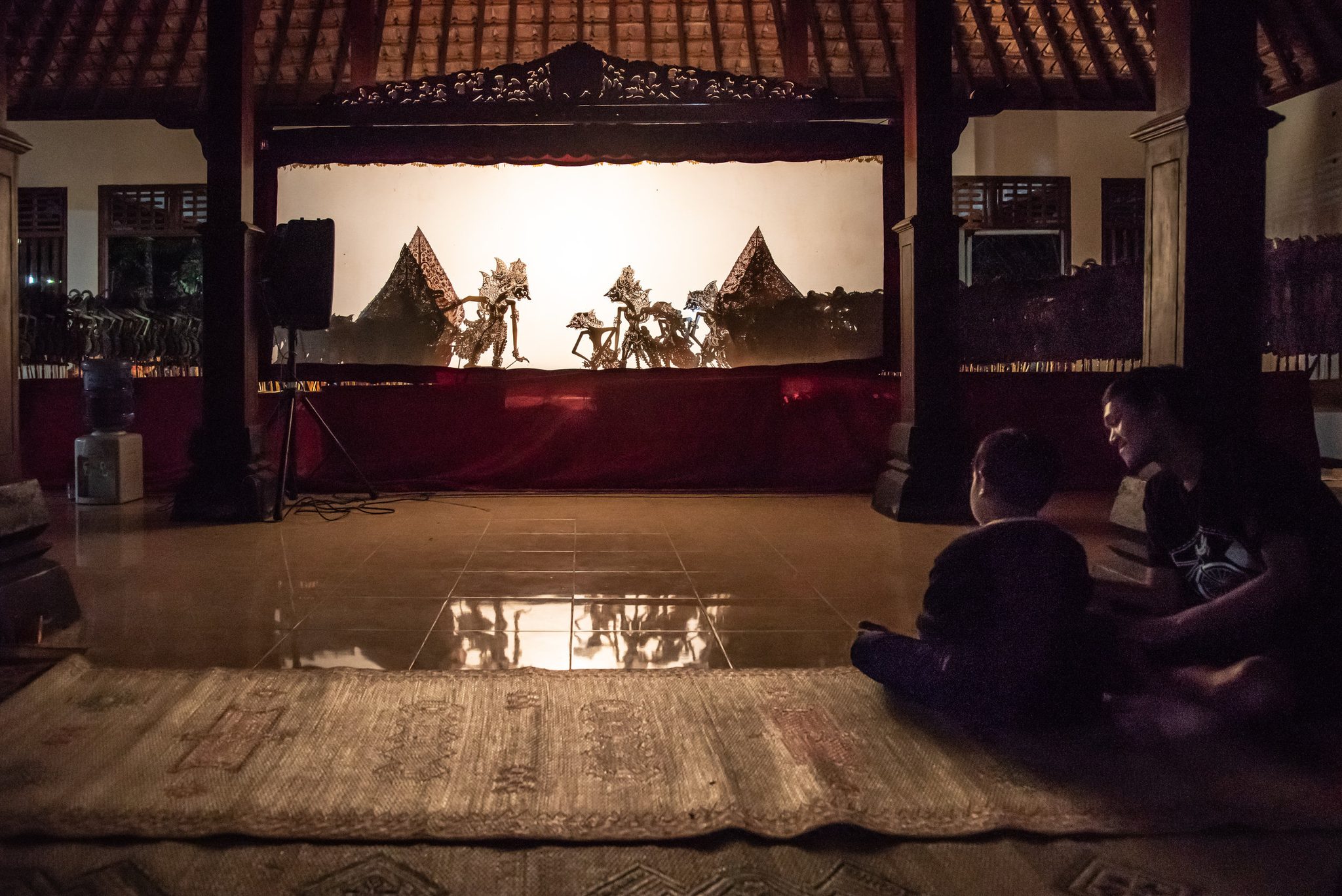 Father and child enjoy the local Wayang Kulit performance