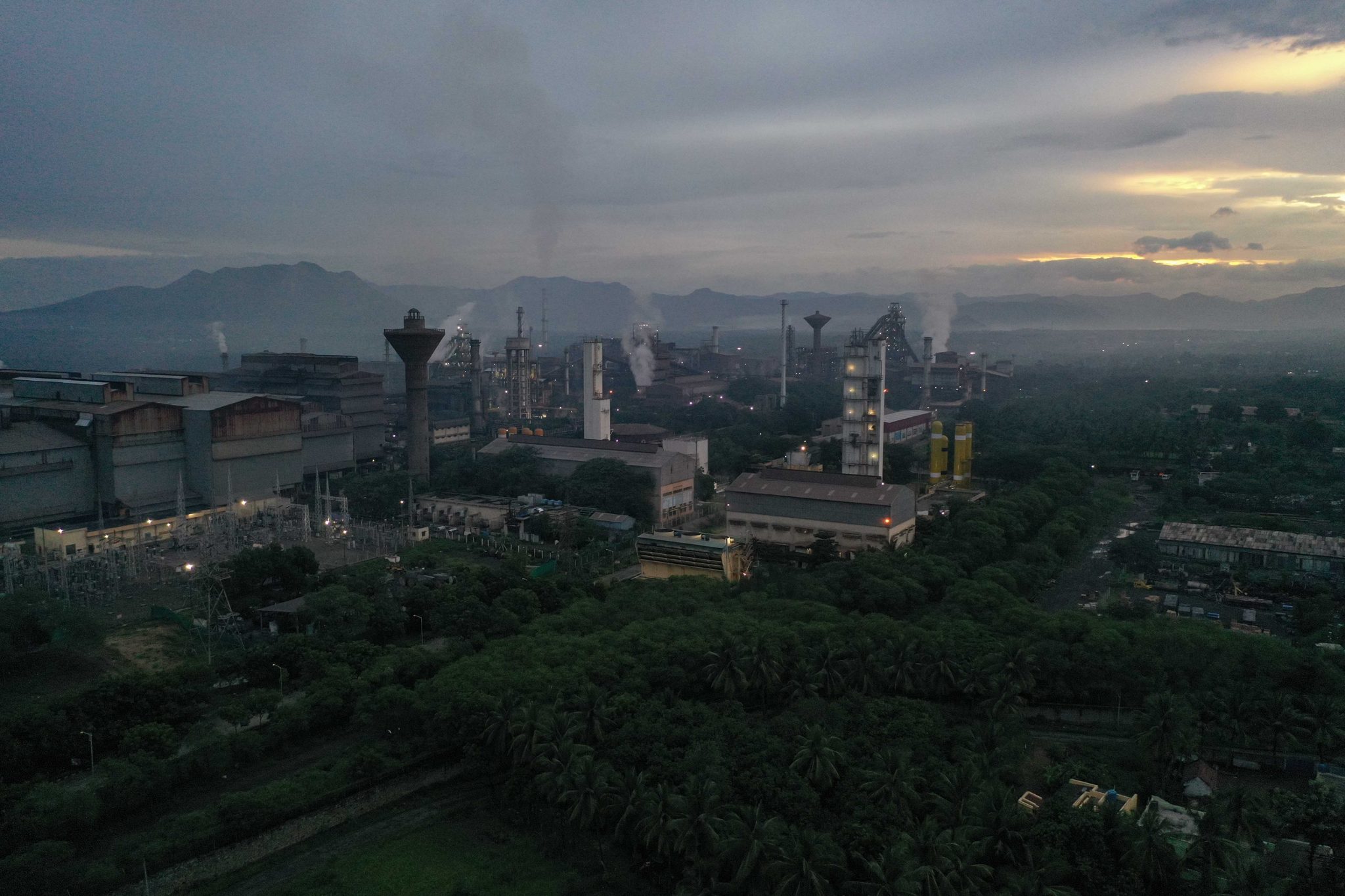 Smokestacks rise from the mill as dawn breaks over the plain.