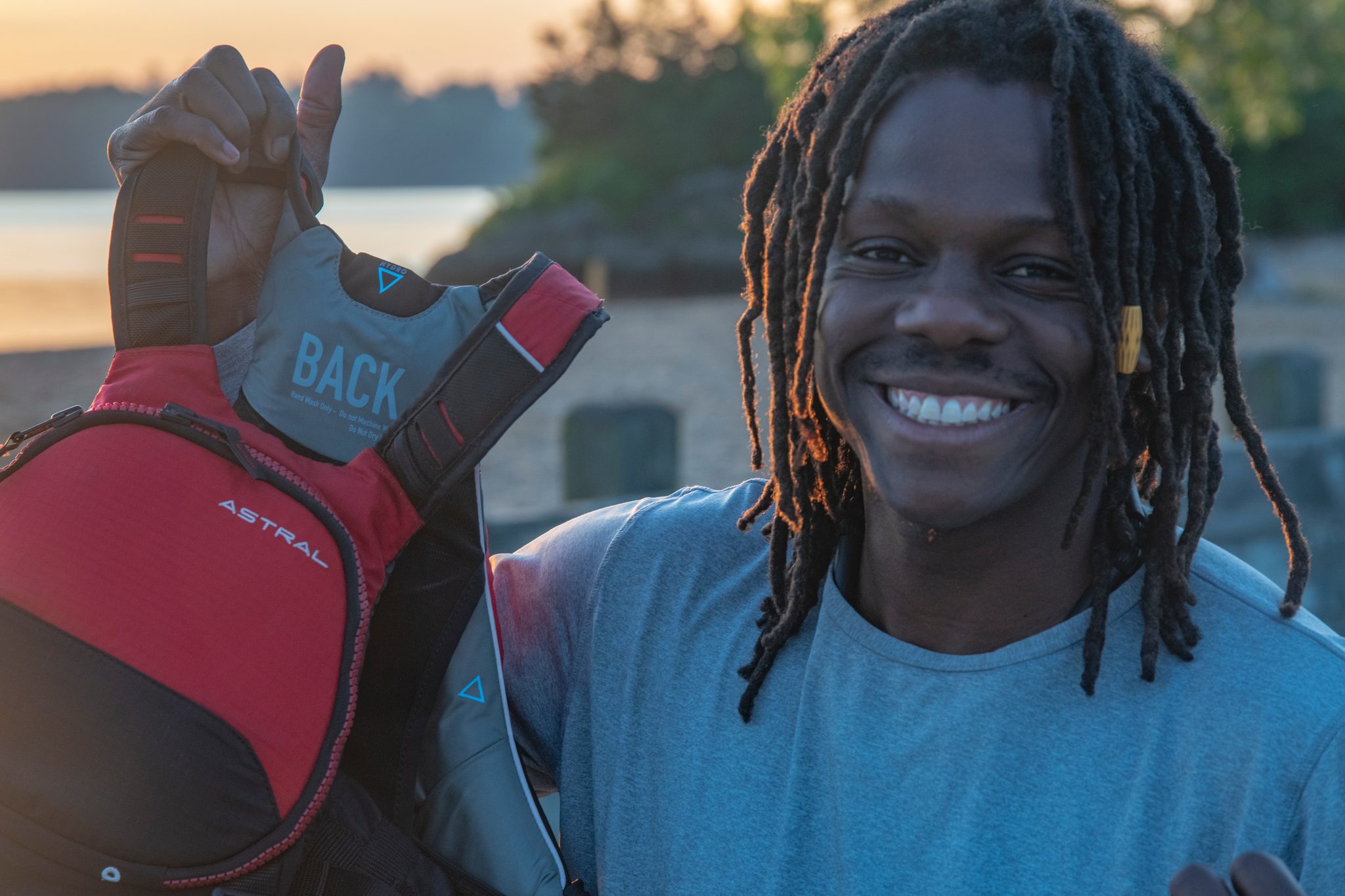 Life vest held up in one hand and a wide grin, Chev ready to go back out.