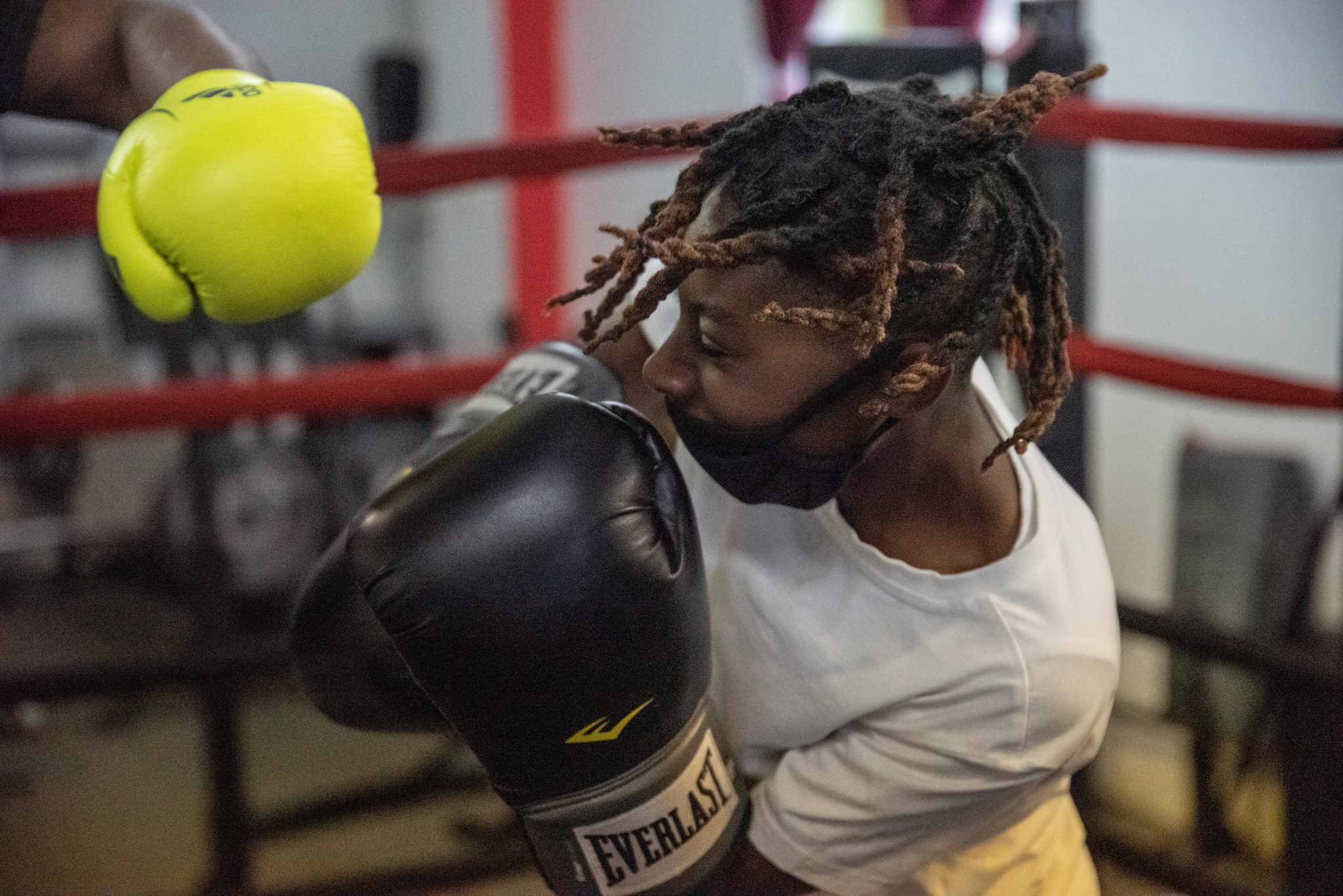 He ducks under a yellow glove, dreadlocks flying.