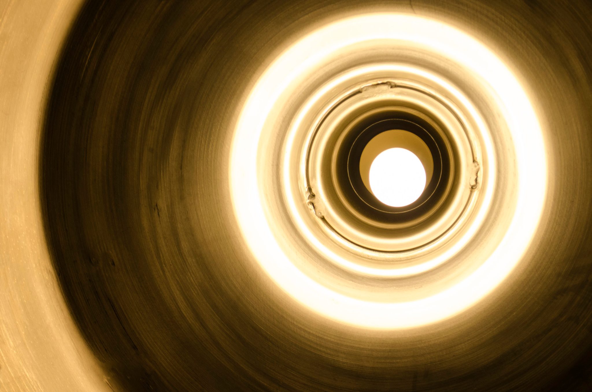 Rings of light spiral down into a glowing tunnel.