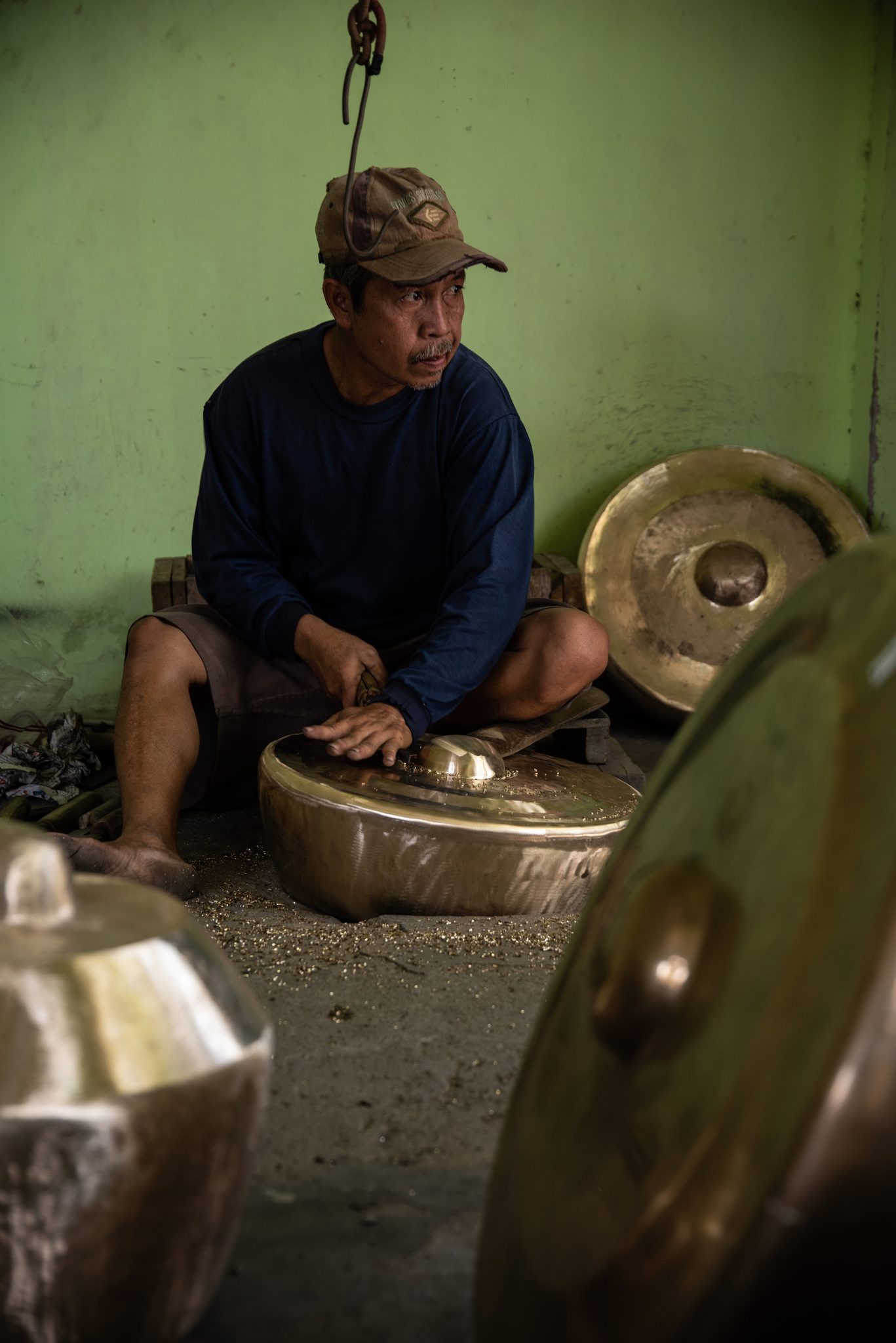 He taps at a smaller gong, listening as much as looking.