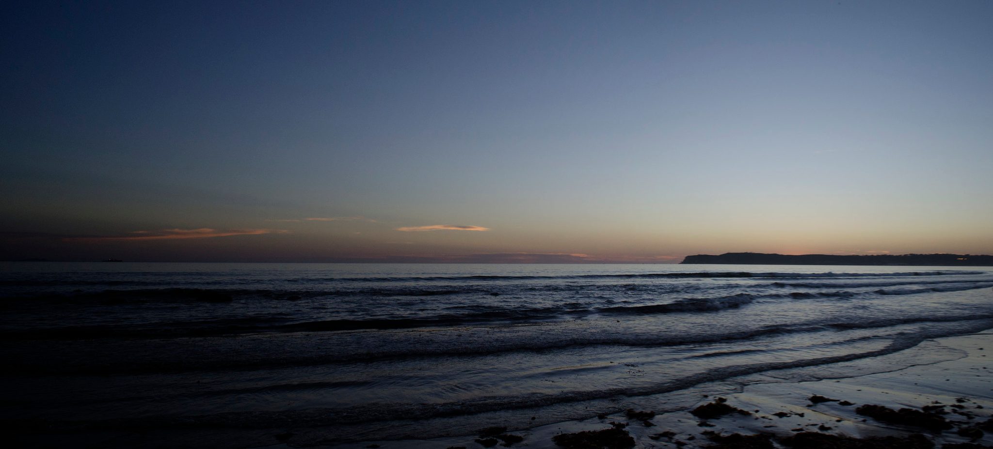 The last light fades over the Pacific as the waves roll in.