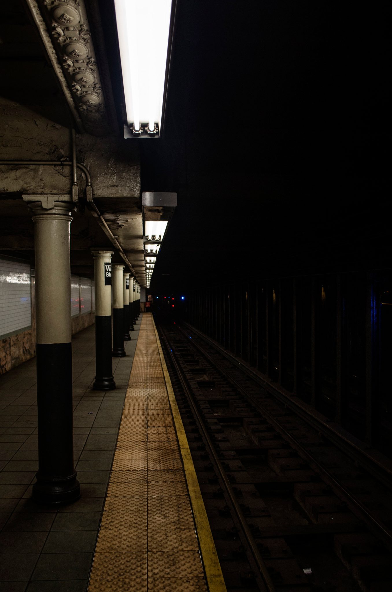 An empty subway platform stretches off into the dark.