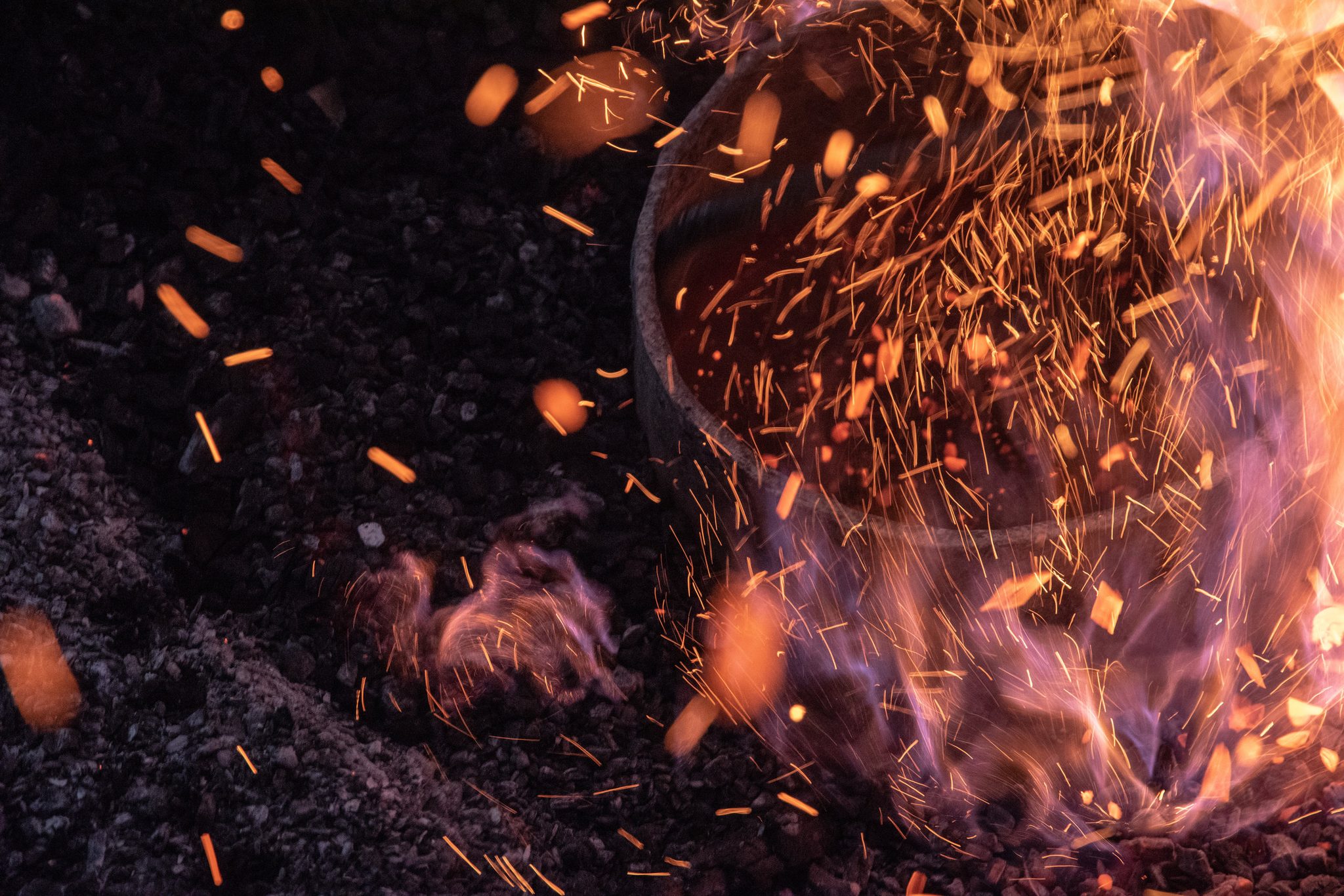 The metal heats in its crucible, flames licking purple at the rim.