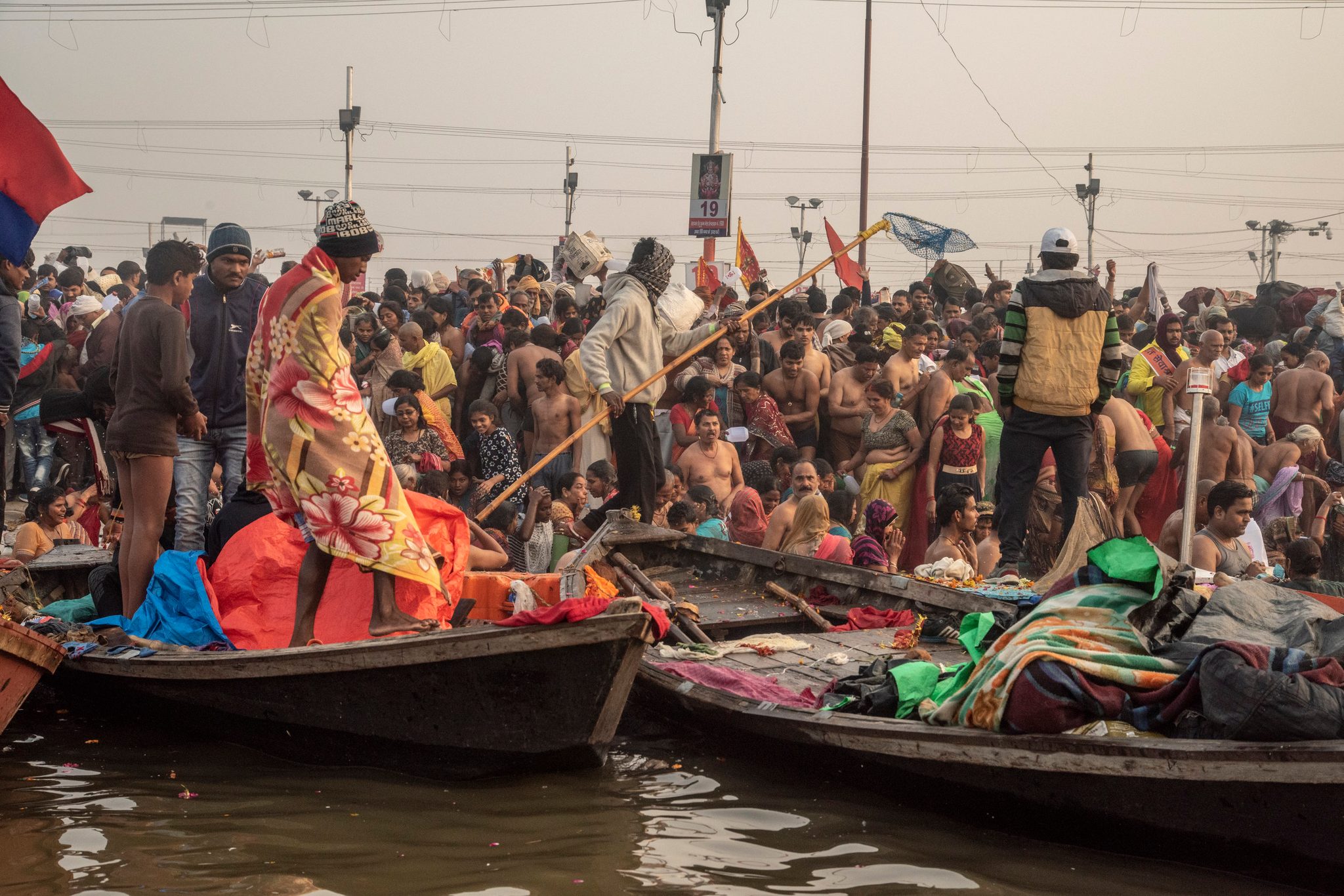 Boats line the shore as a mass of people gather to bathe in the ganges