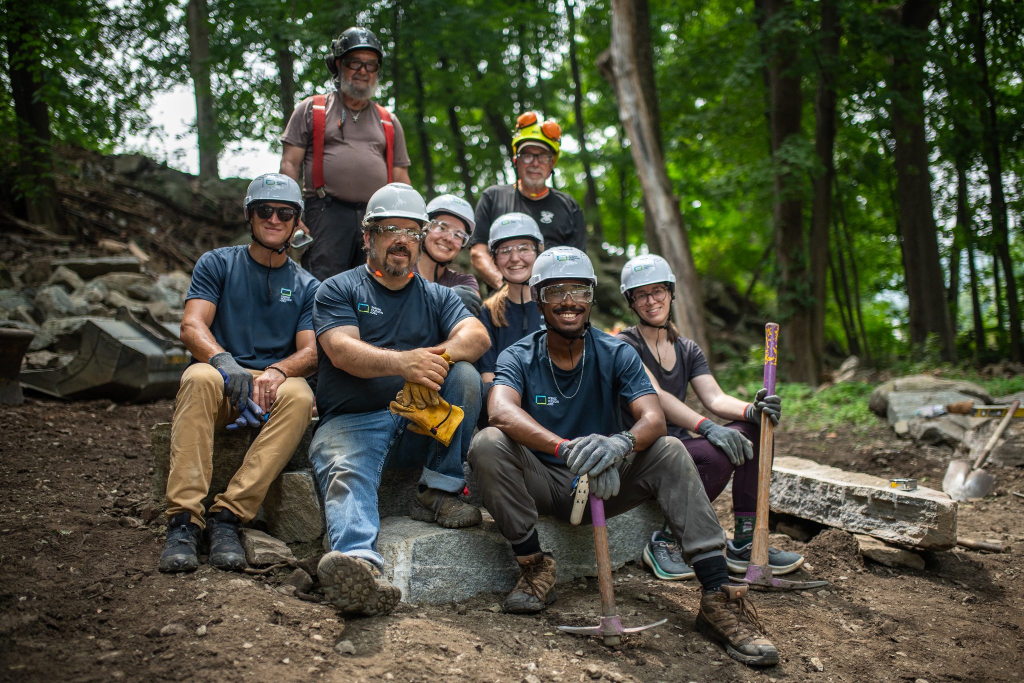 The crew sits together on the new granite steps at the end of the job.