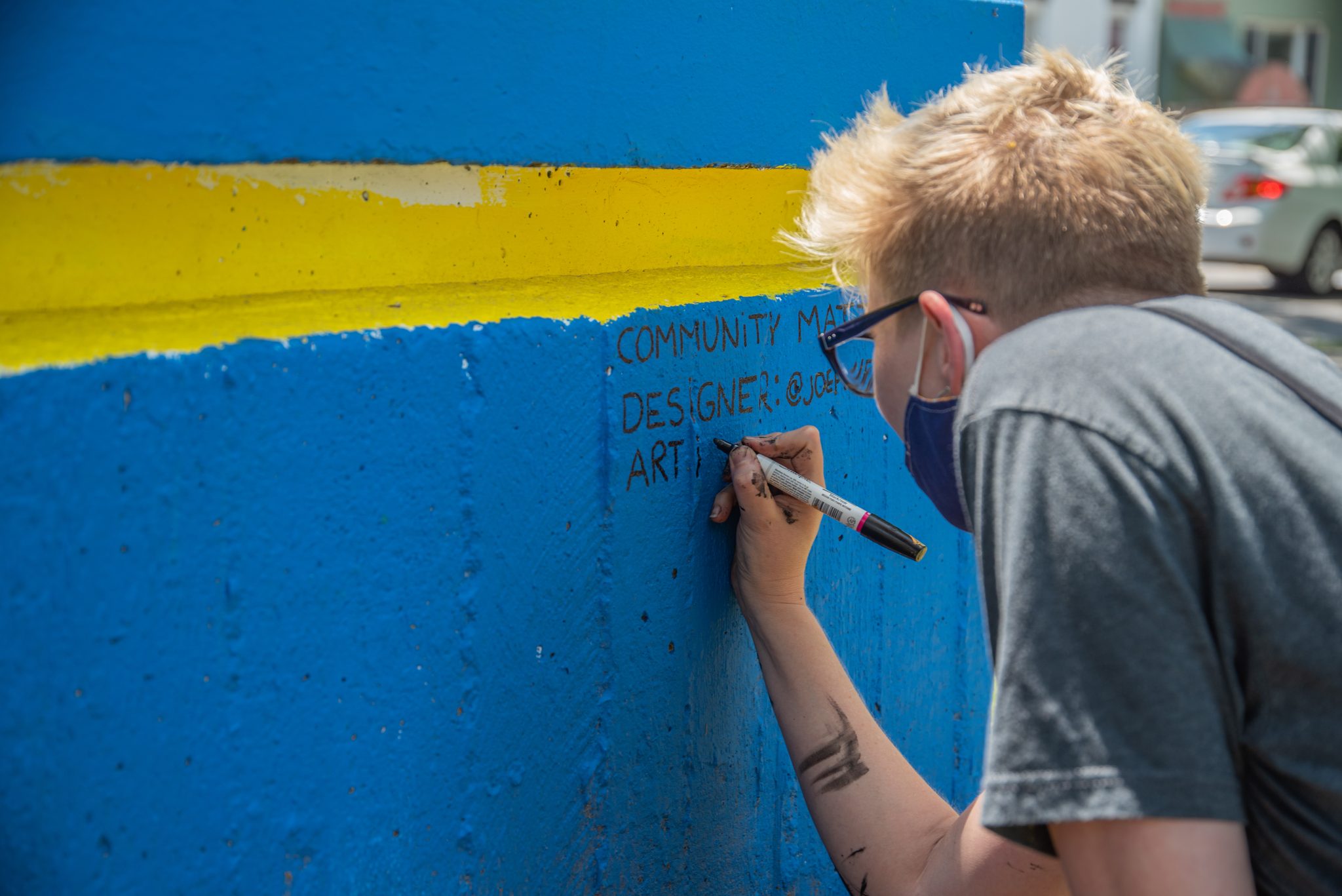 An artist signs the wall, the last stroke on the project.