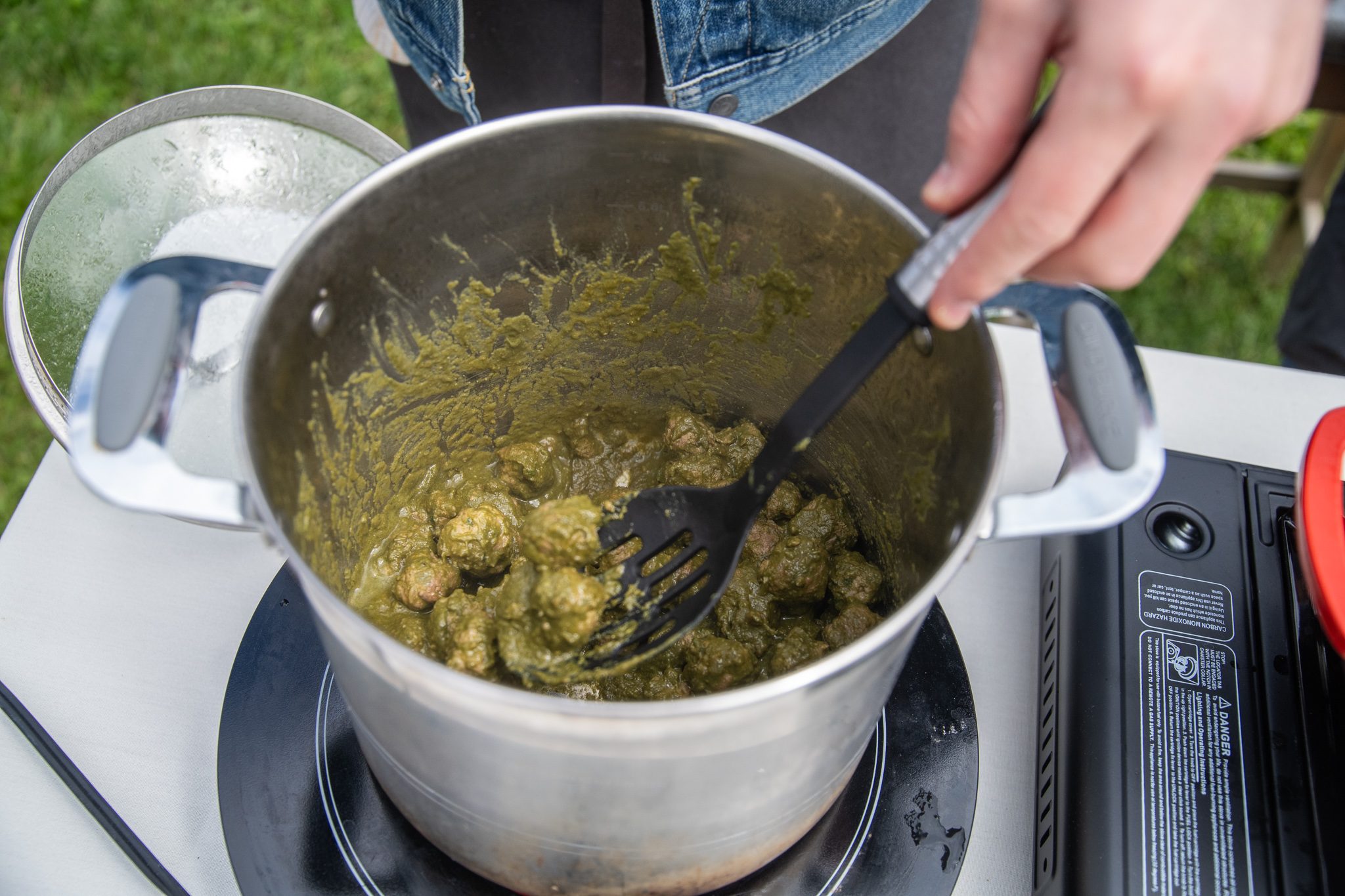 A pot of green herb sauce gets a stir at the cooking demonstration.