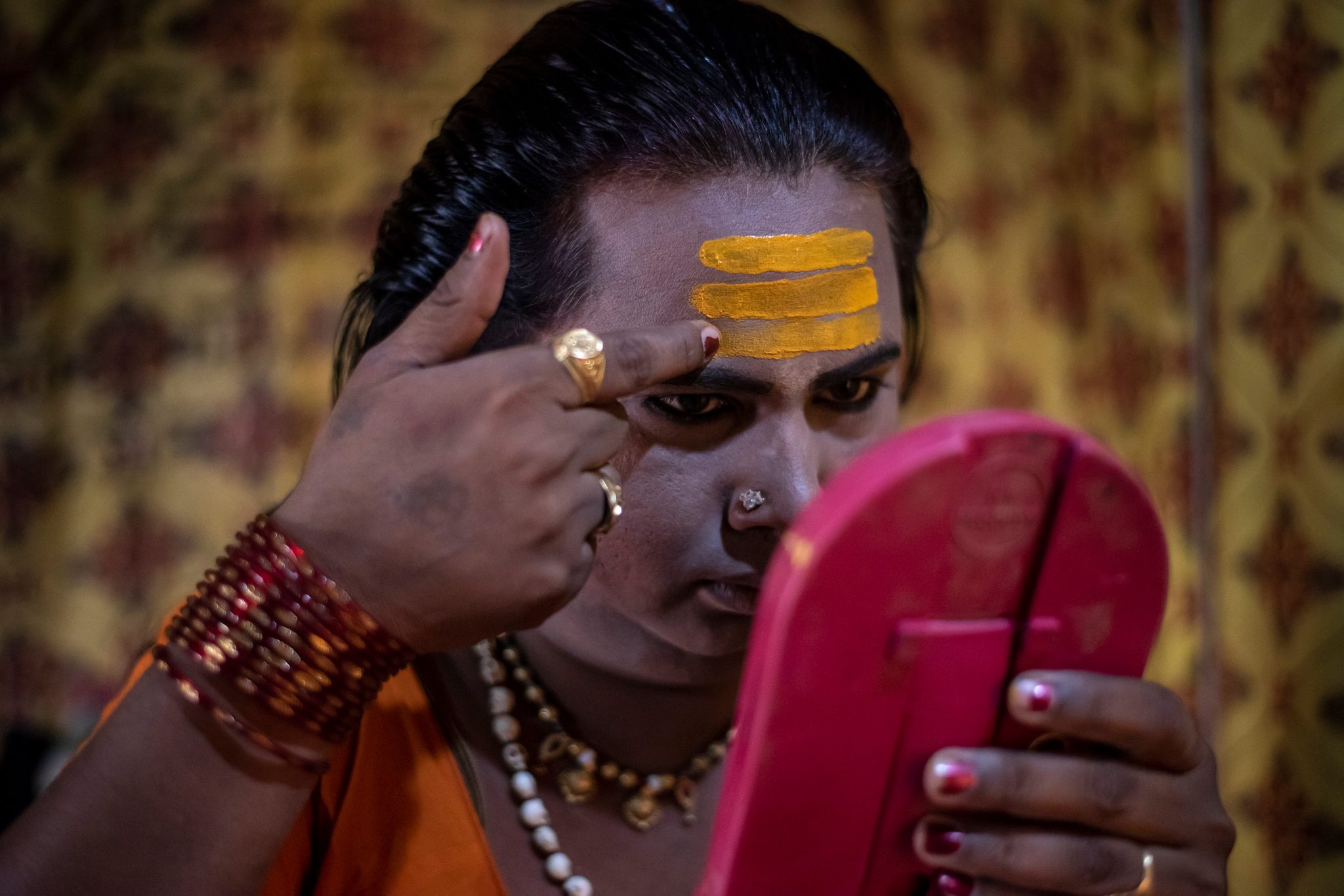 A Kinnar Akada (transgender) applies makeup