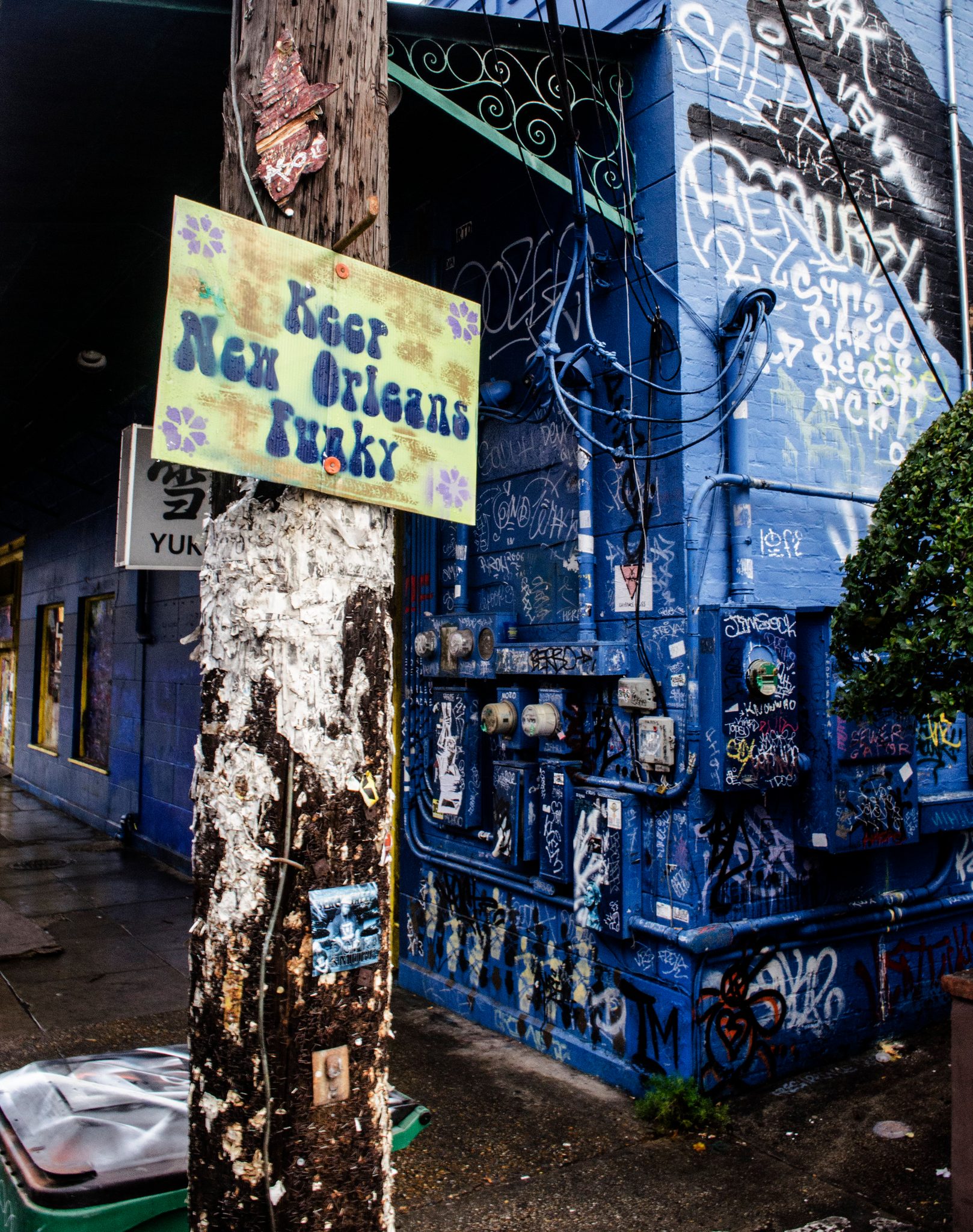 Keep New Orleans Funky, says the sign nailed to the pole outside a blue building.