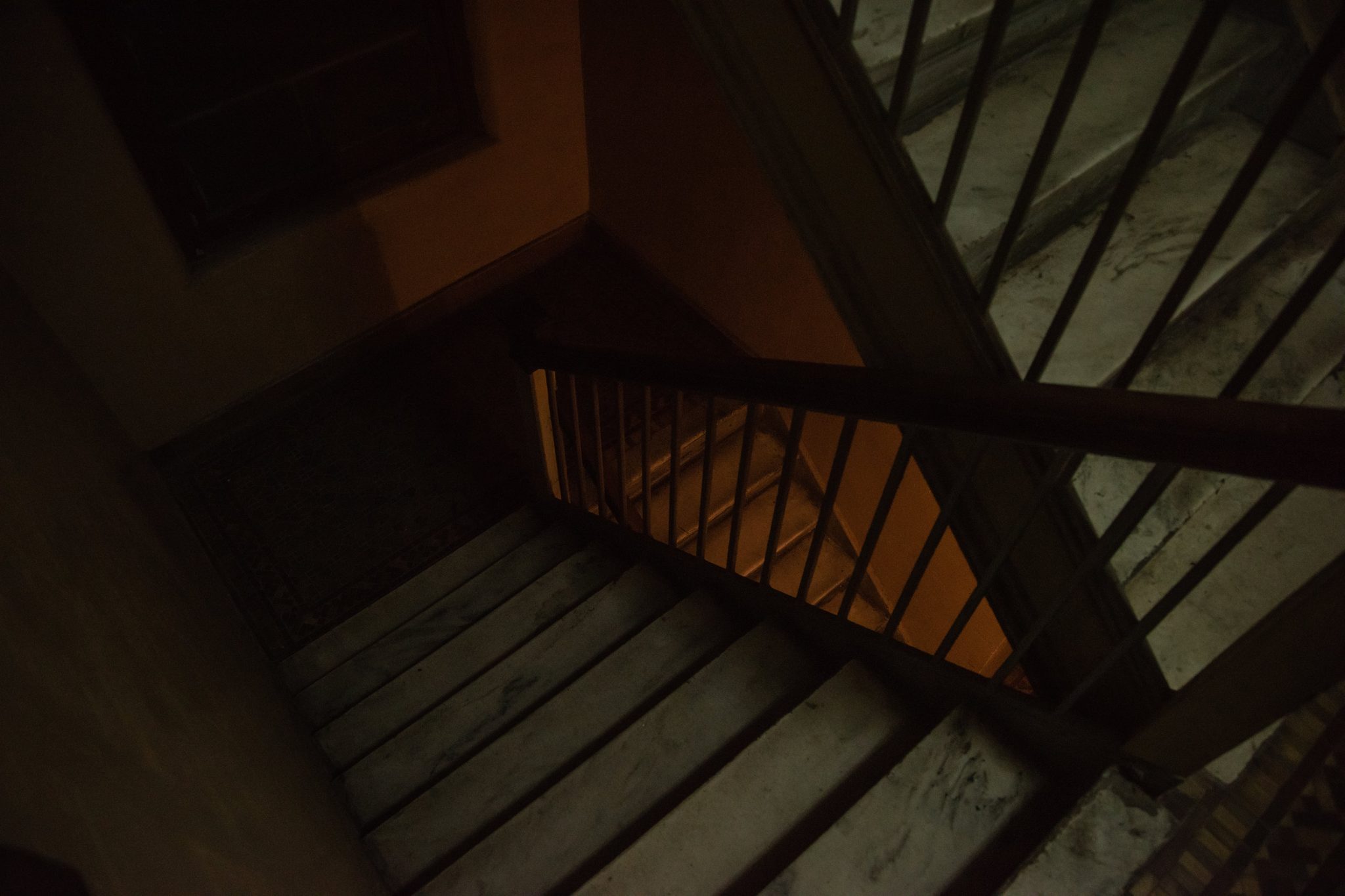 The stairwell winds down through the old building.