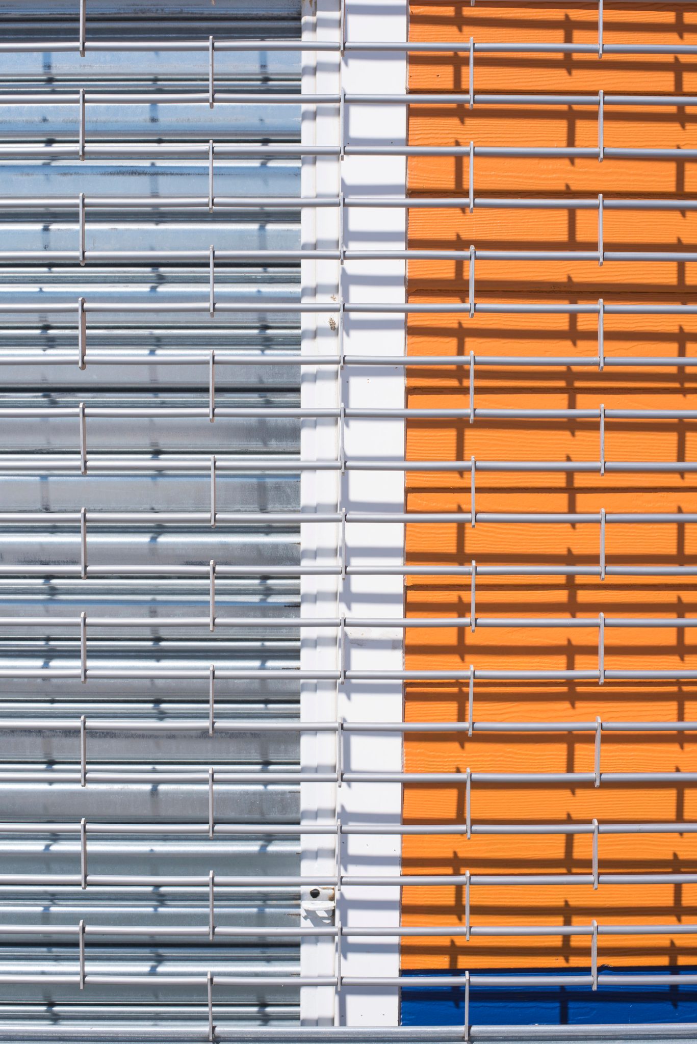 Stripes of orange, silver and white on a building's face.