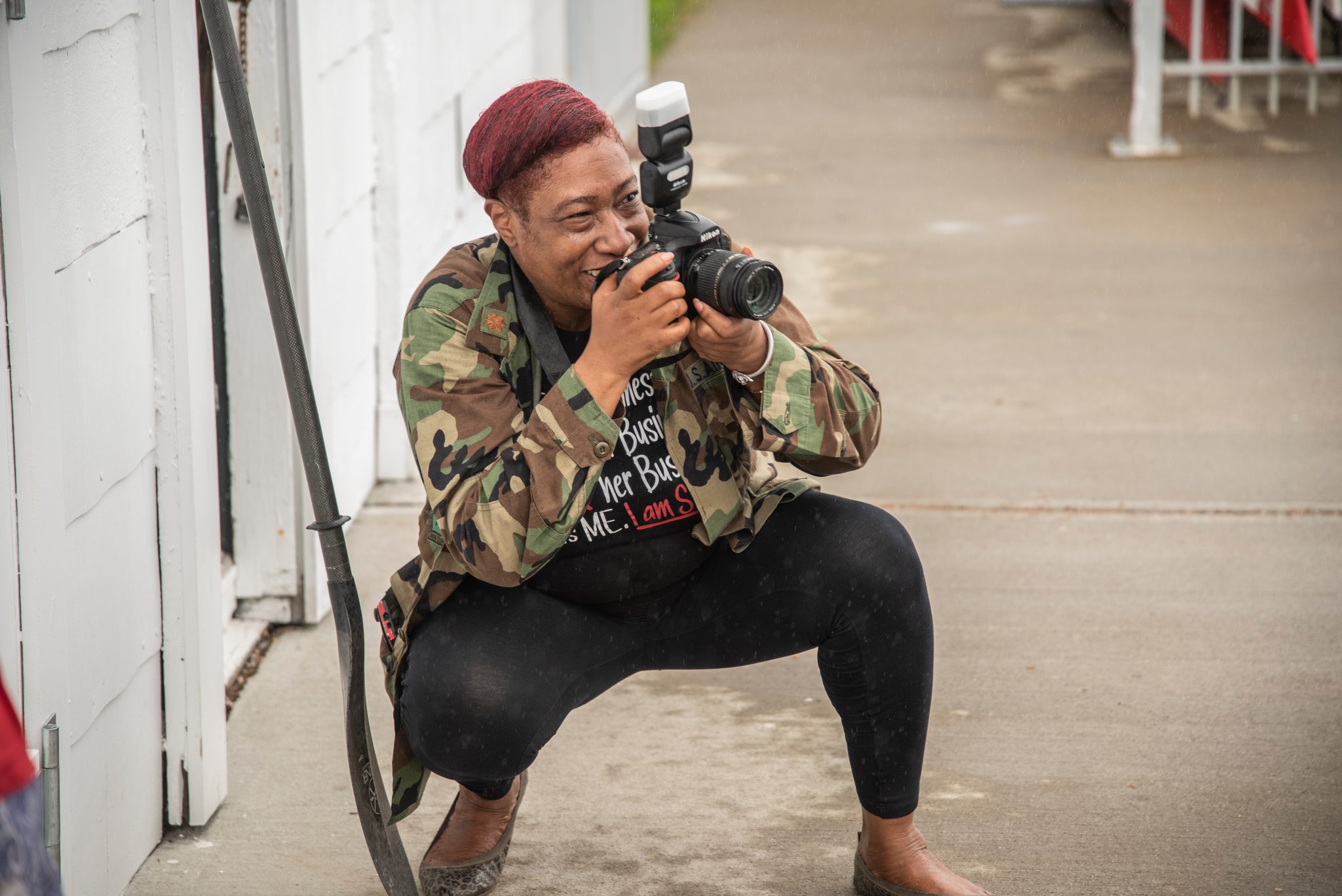 A photographer in a camo jacket drops low on the boardwalk and waits for the moment to come to him.