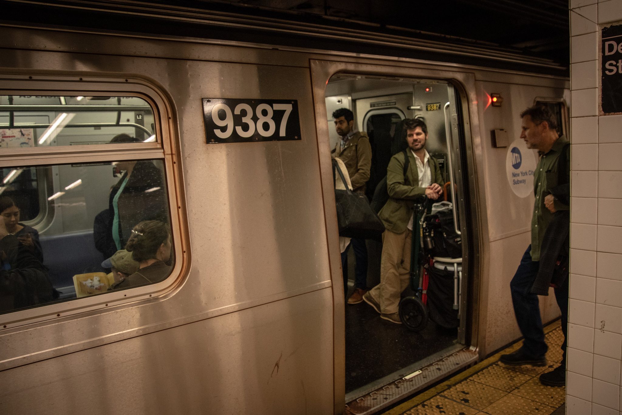Emmet rides in with the gear cart, the subway doors open onto the platform.