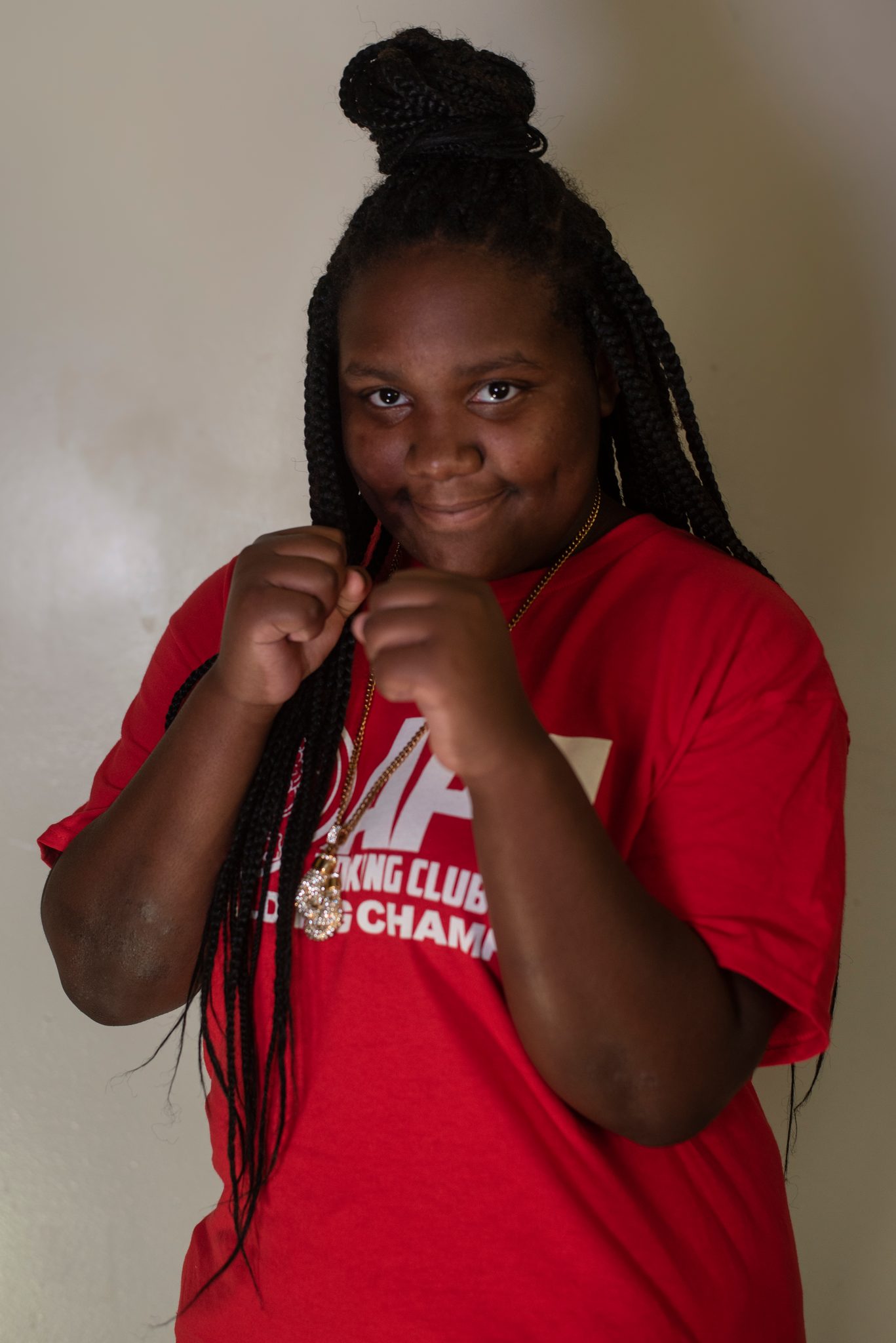 Now her guard comes up, braids spilling over her fists and a small smile breaking through.