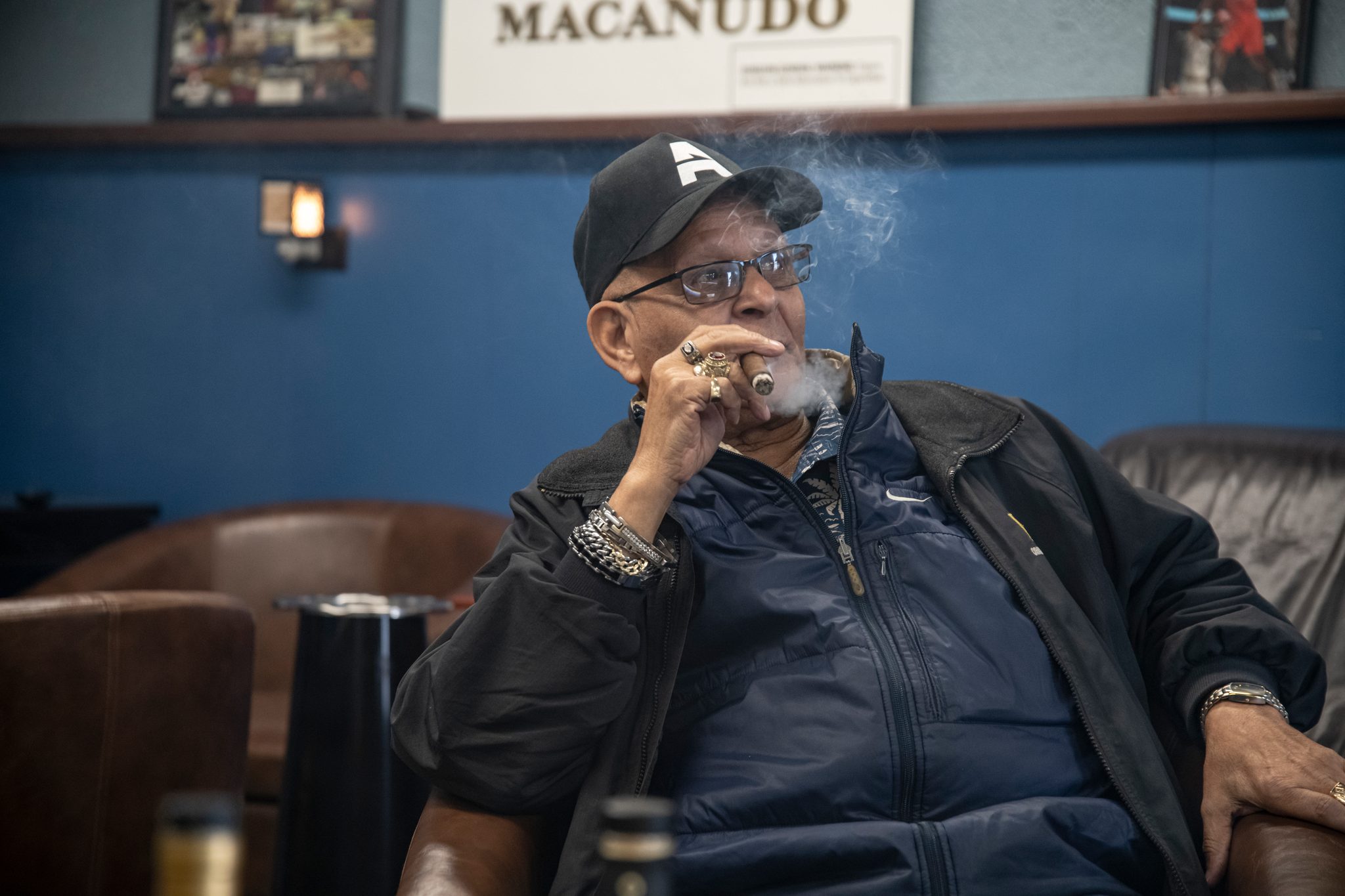 An elder draws on a cigar in the lounge.