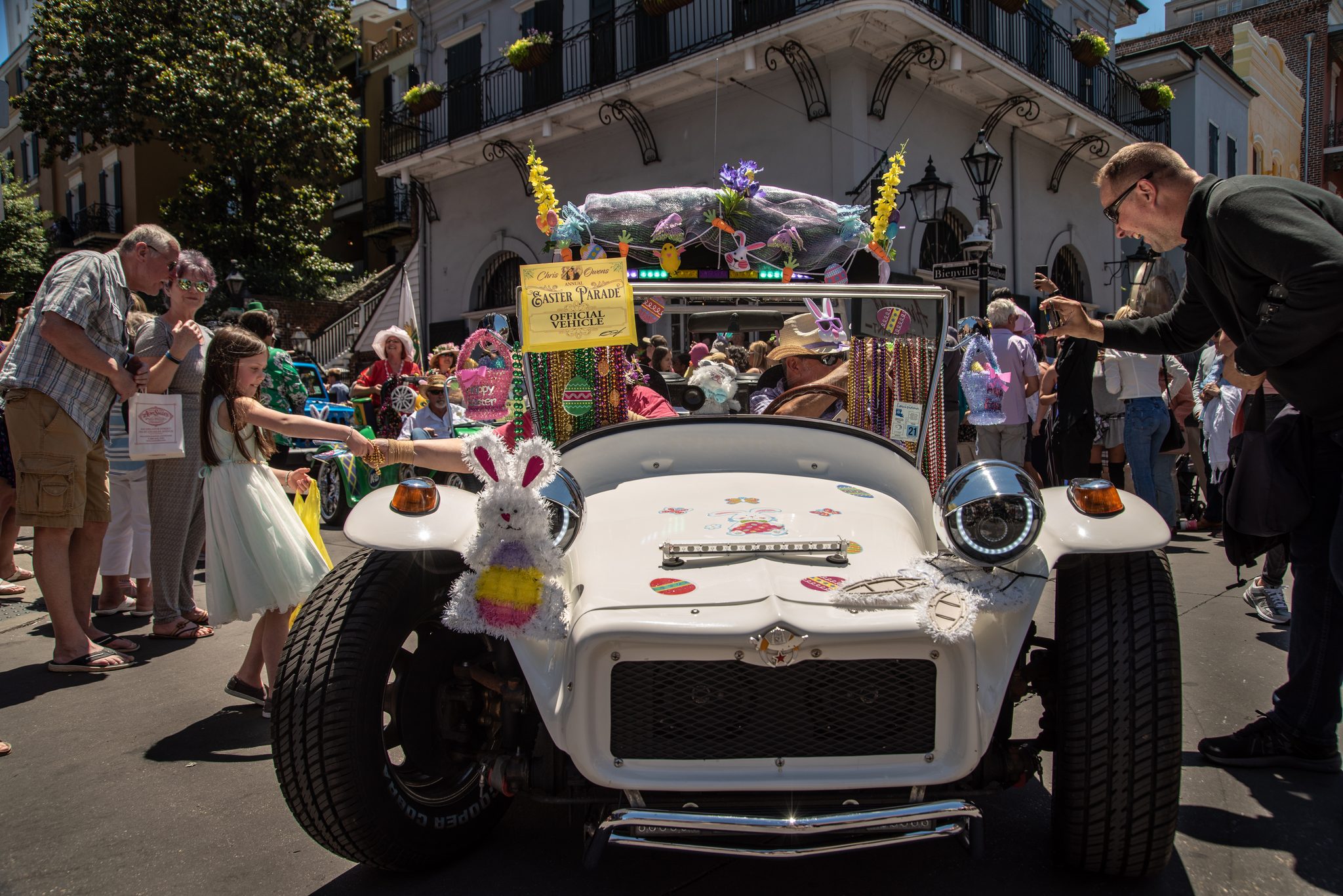Bunny ears ride the hood of the lead car as it inches through the Easter crowd.