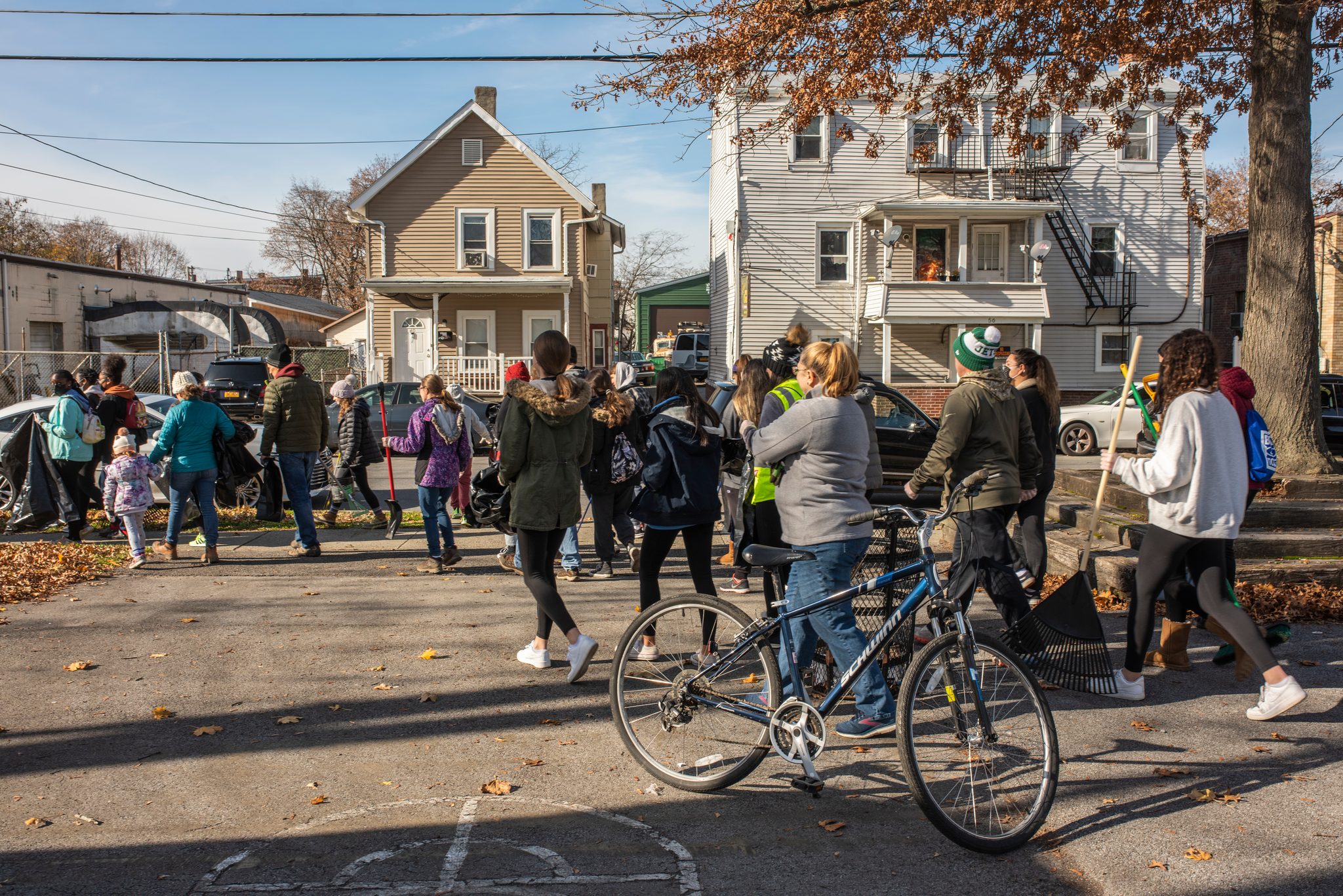 The youth cleanup heads out down the street, a bicycle leaning in the foreground.