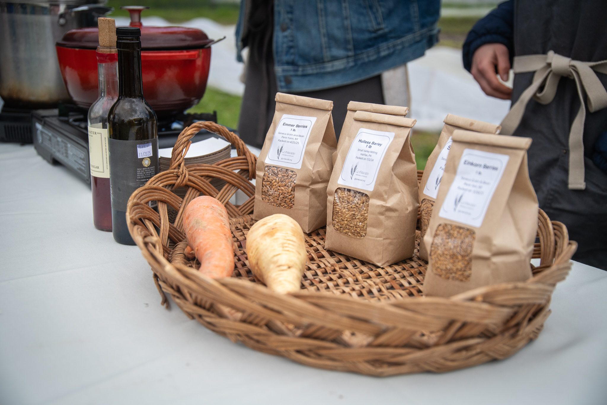 Bags of grain and a few roots wait in a basket at the cooking demo.