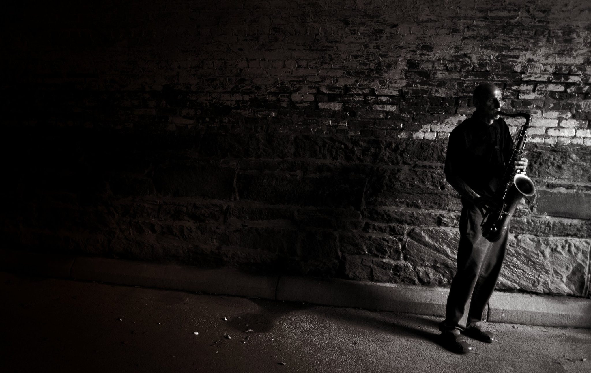 Alone beneath a stone bridge in Central Park, a man paints the air with the warm tones of his saxophone.