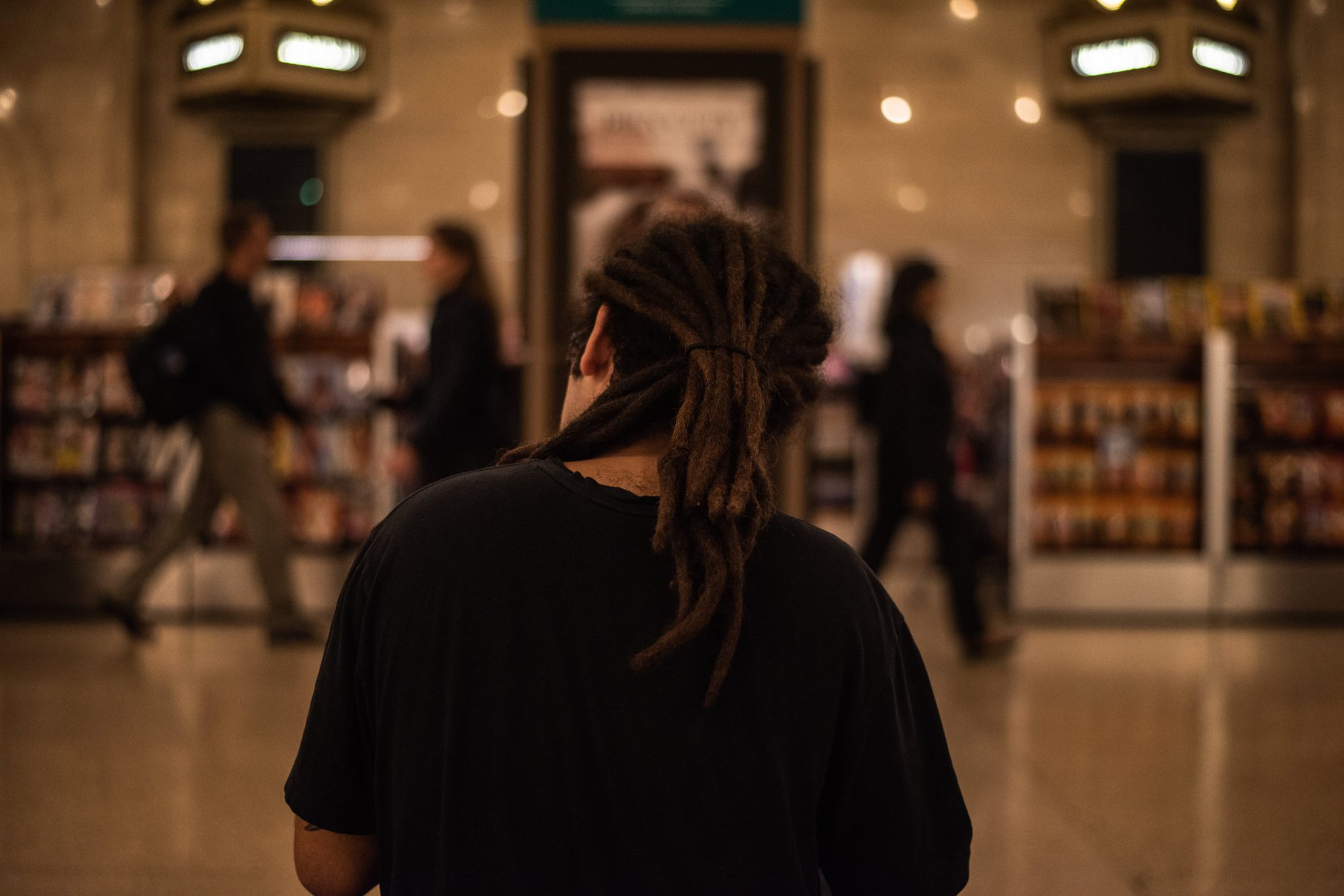 From behind, the dreadlocks and the terminal blur of shoppers and commuters.