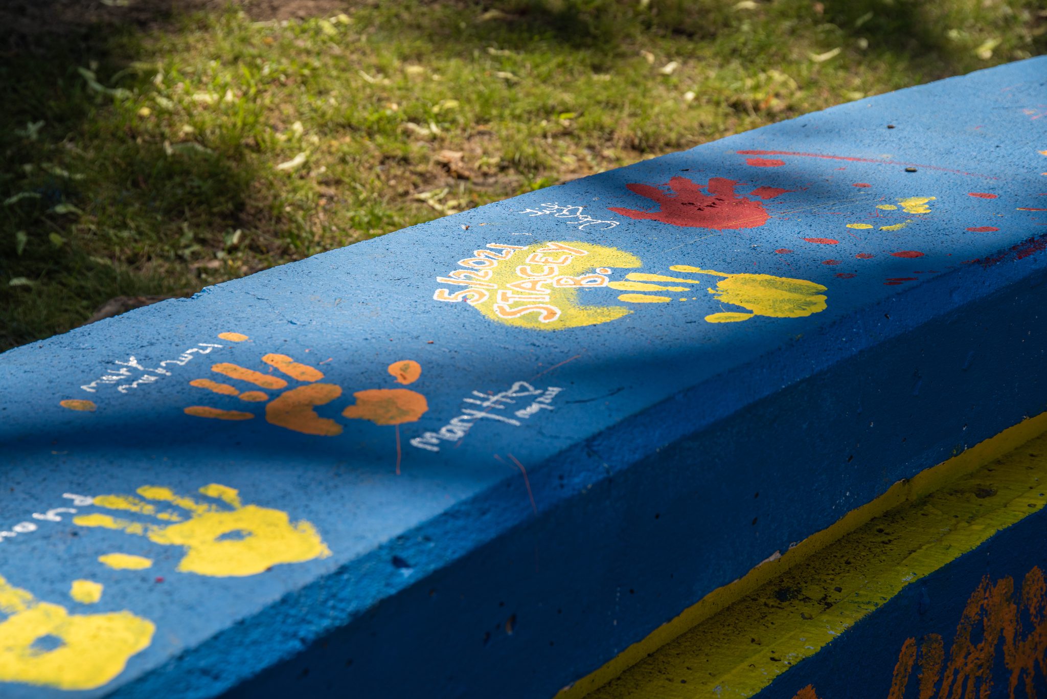 Handprints in every color, pressed into the wall by the people who painted it.